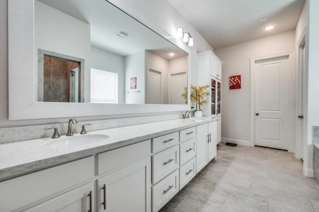Dual vanity with undermount sinks and brushed nickel fixtures, set against a full-width framed mirror