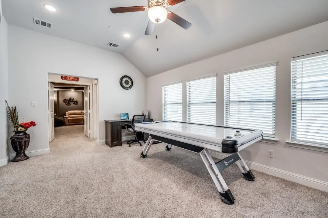 Spacious room with vaulted ceiling featuring recessed lighting and a ceiling fan