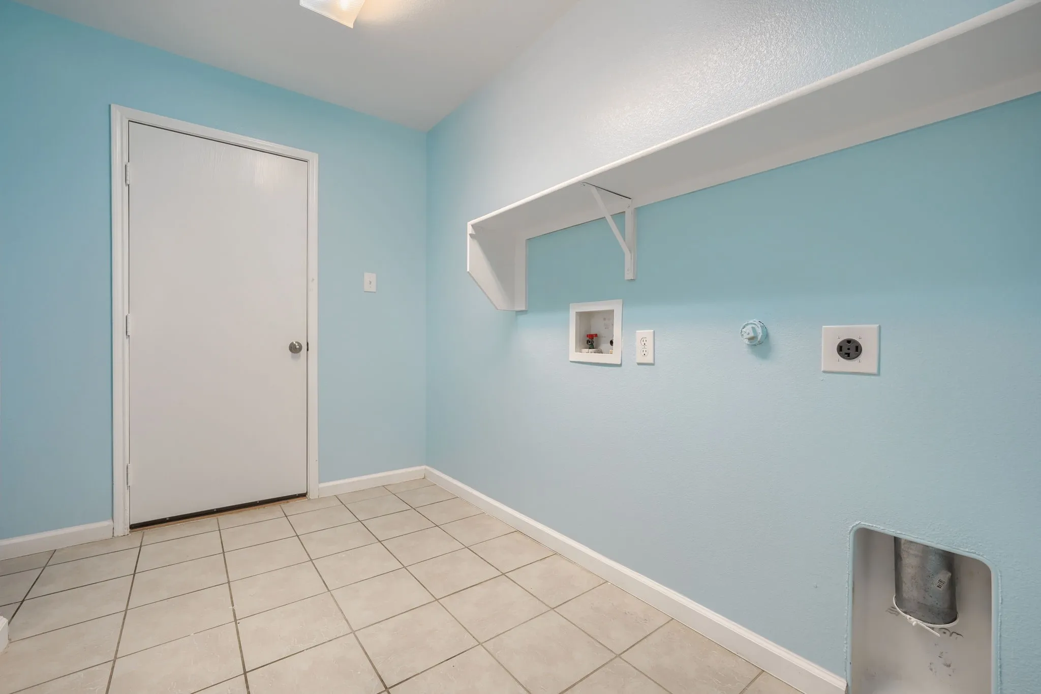 Utility room featuring light blue walls, white trim, and a full-light flush mount ceiling fixture