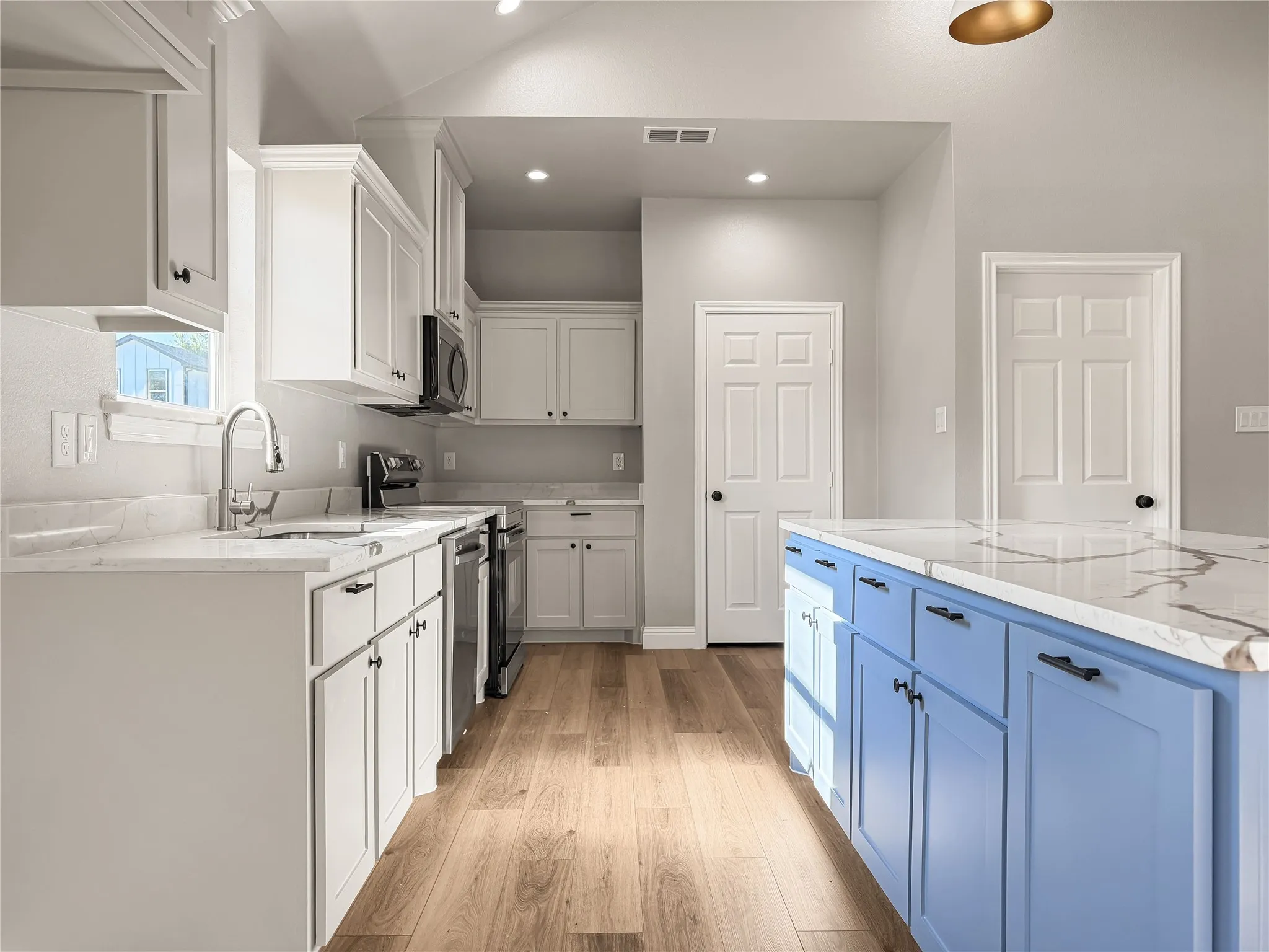 White vanity with shaker-style cabinetry, a white countertop with brown veining, and a built-in sink