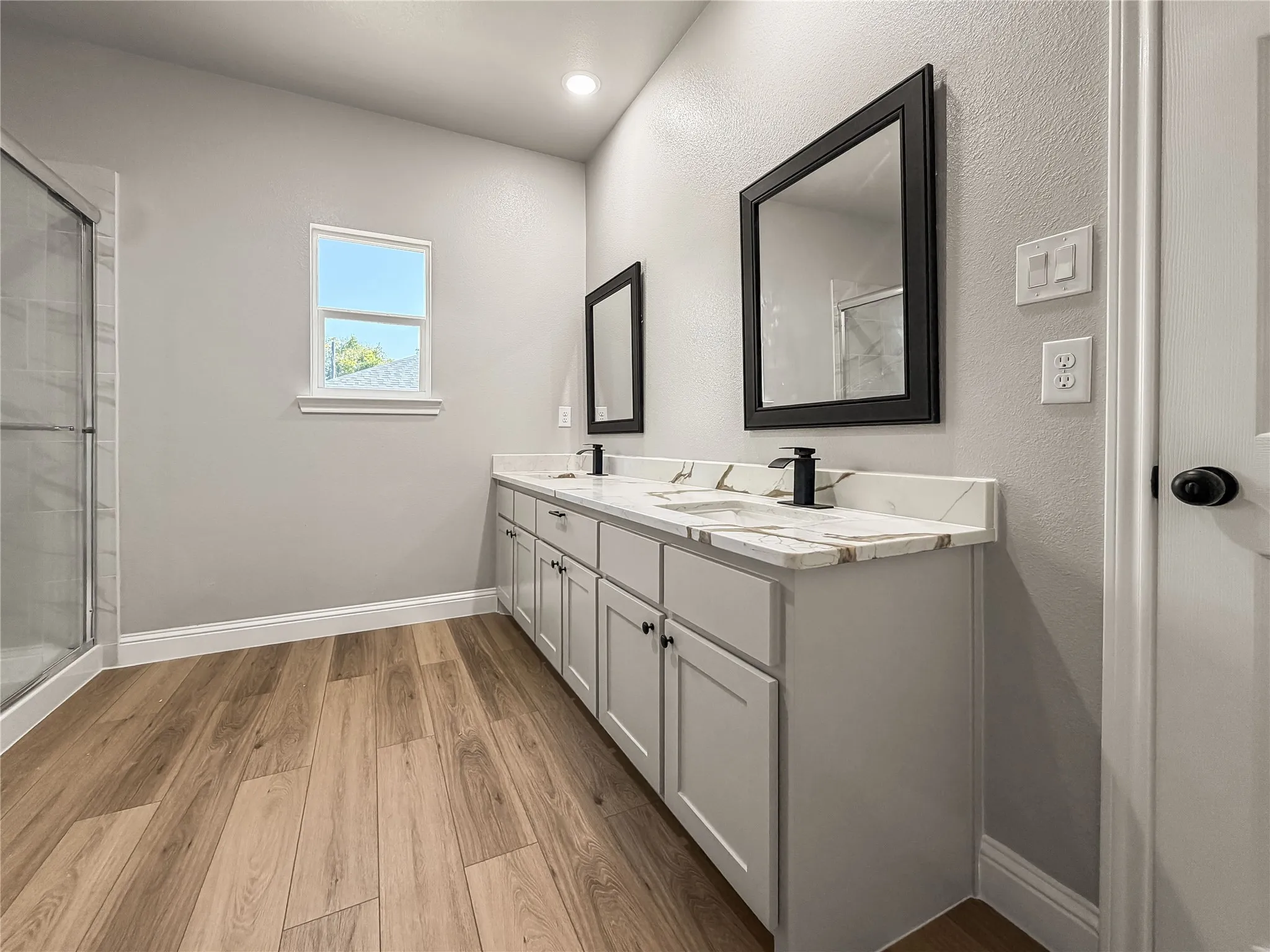 Spacious backyard featuring a large grass lawn, privacy fencing, and a covered patio area