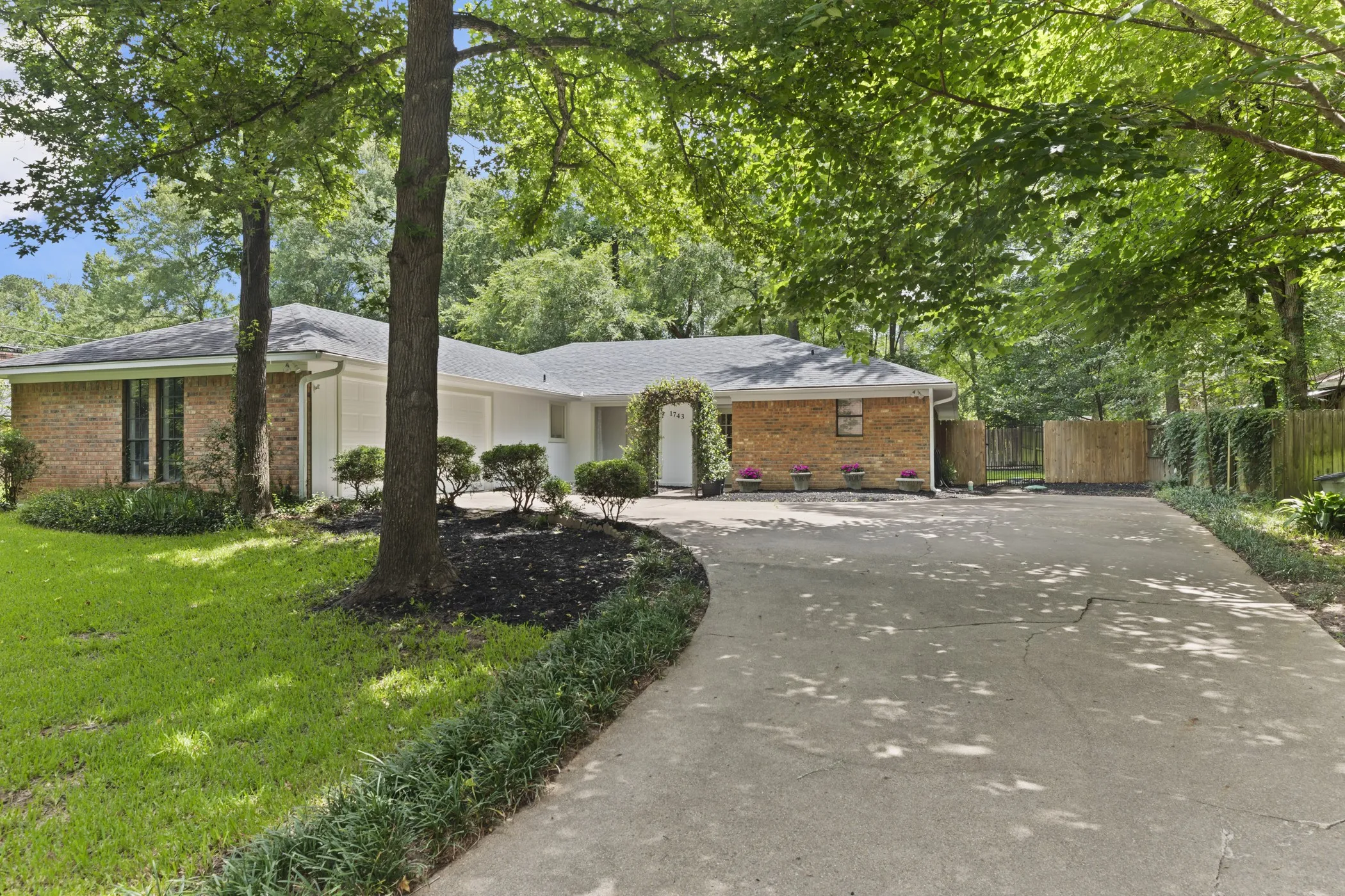Brick and white siding exterior with a dark shingle roof