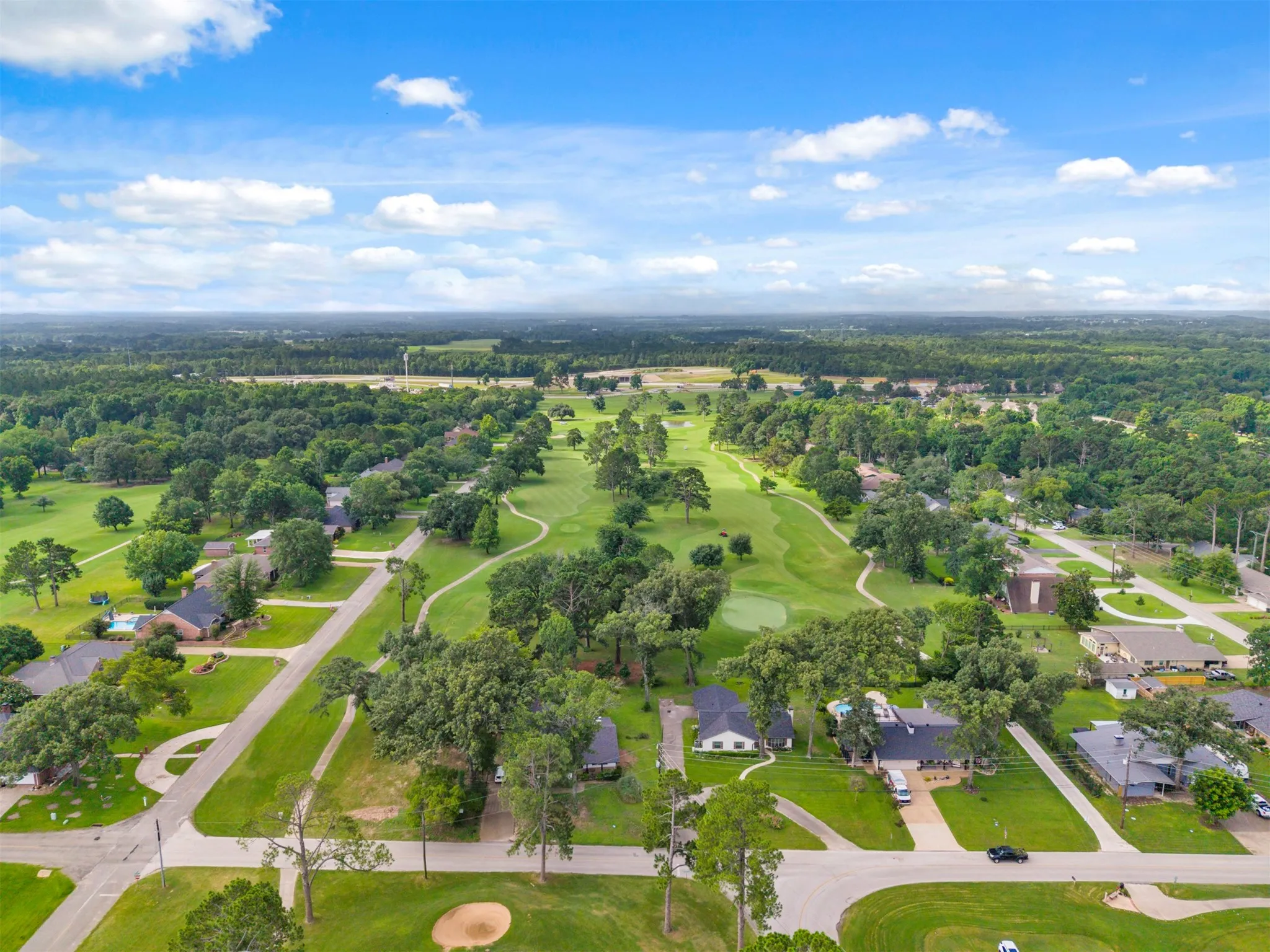 Aerial perspective showcasing a residential area integrated with a golf course