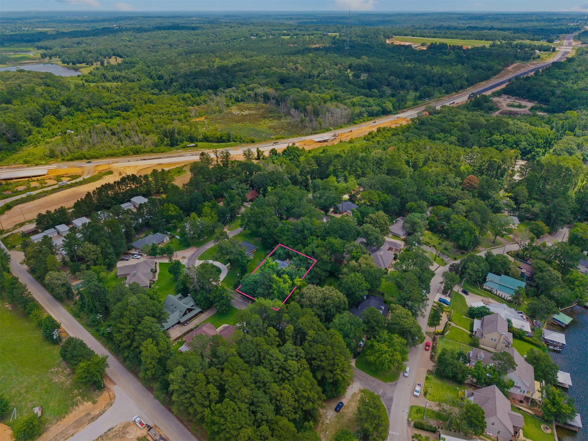 Aerial perspective showcasing a residential property outlined in red, surrounded by mature trees