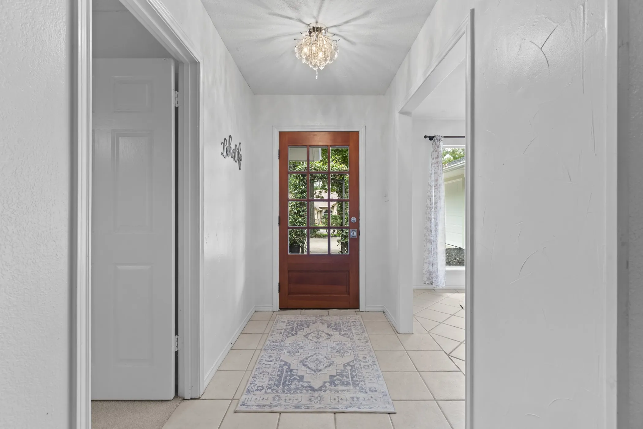 Inviting entryway with a rich wood-finish front door featuring multi-pane glass