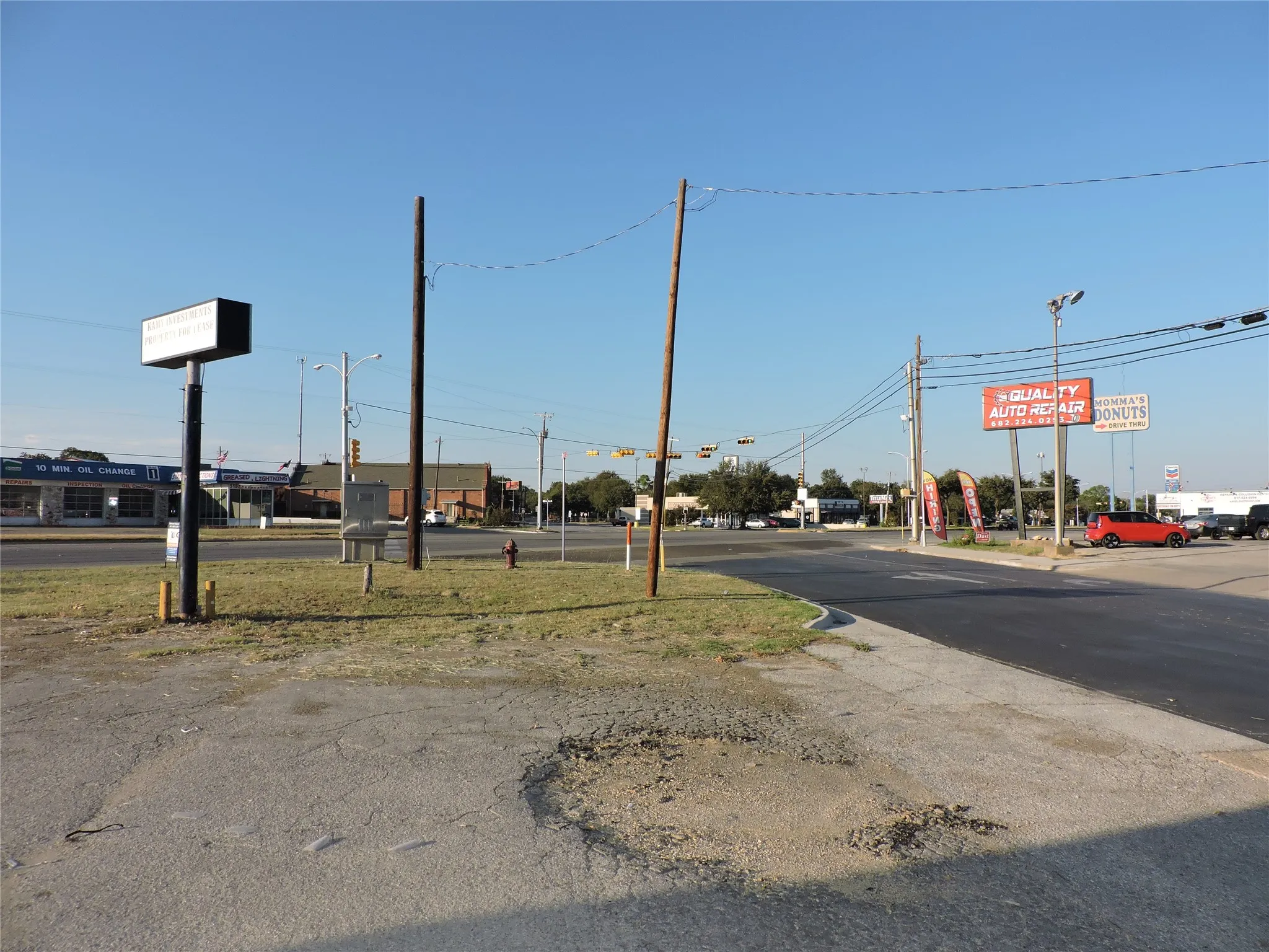 View of asphalt road featuring street lighting and traffic signs