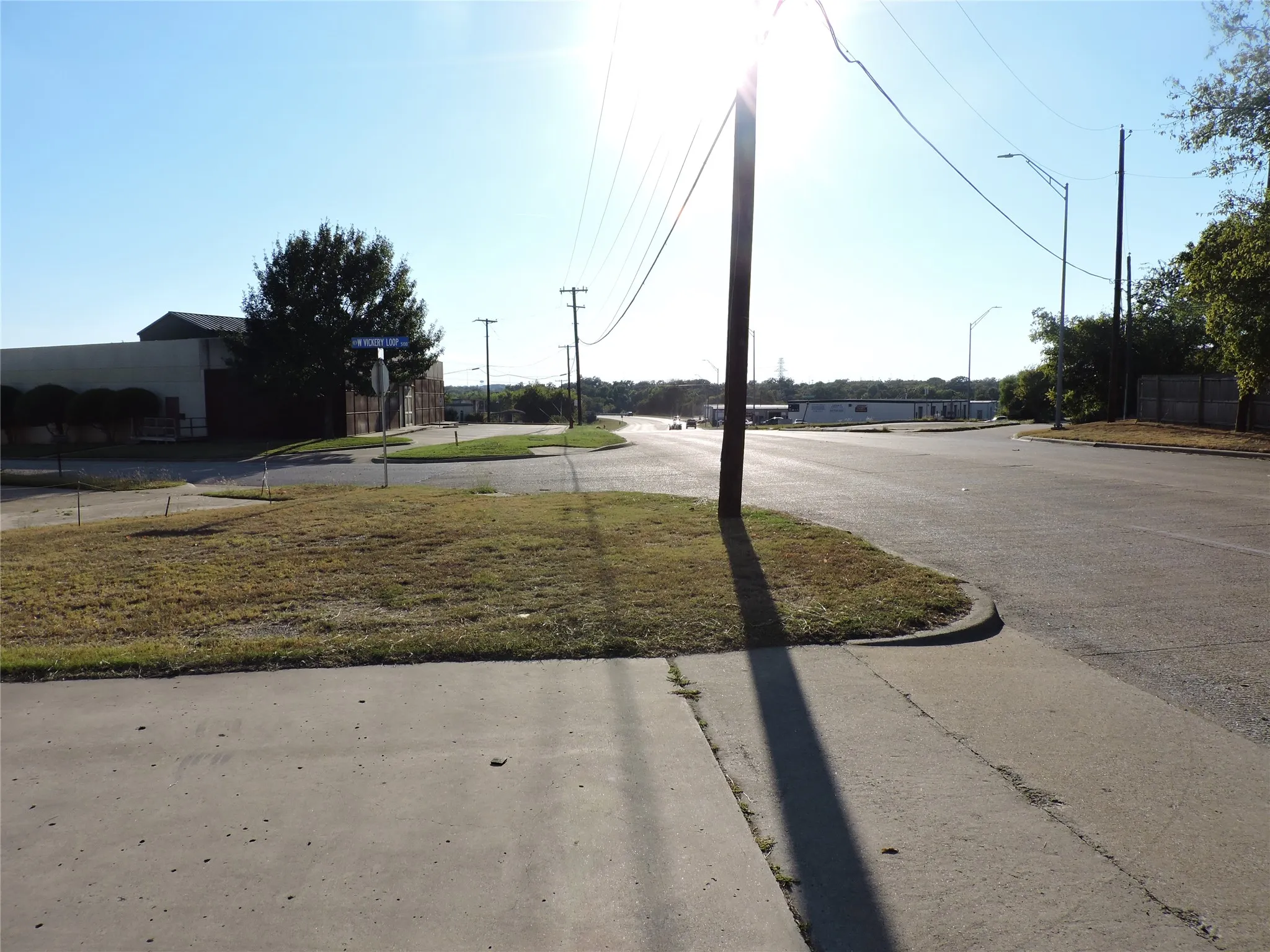 View of asphalt road with curbs and street lighting