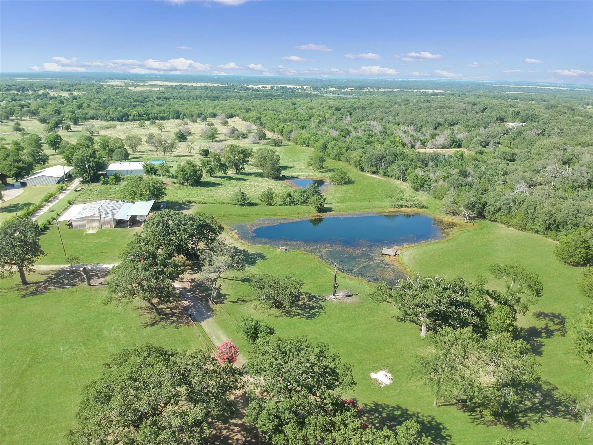 Expansive property featuring two distinct ponds, mature trees, and vast green spaces