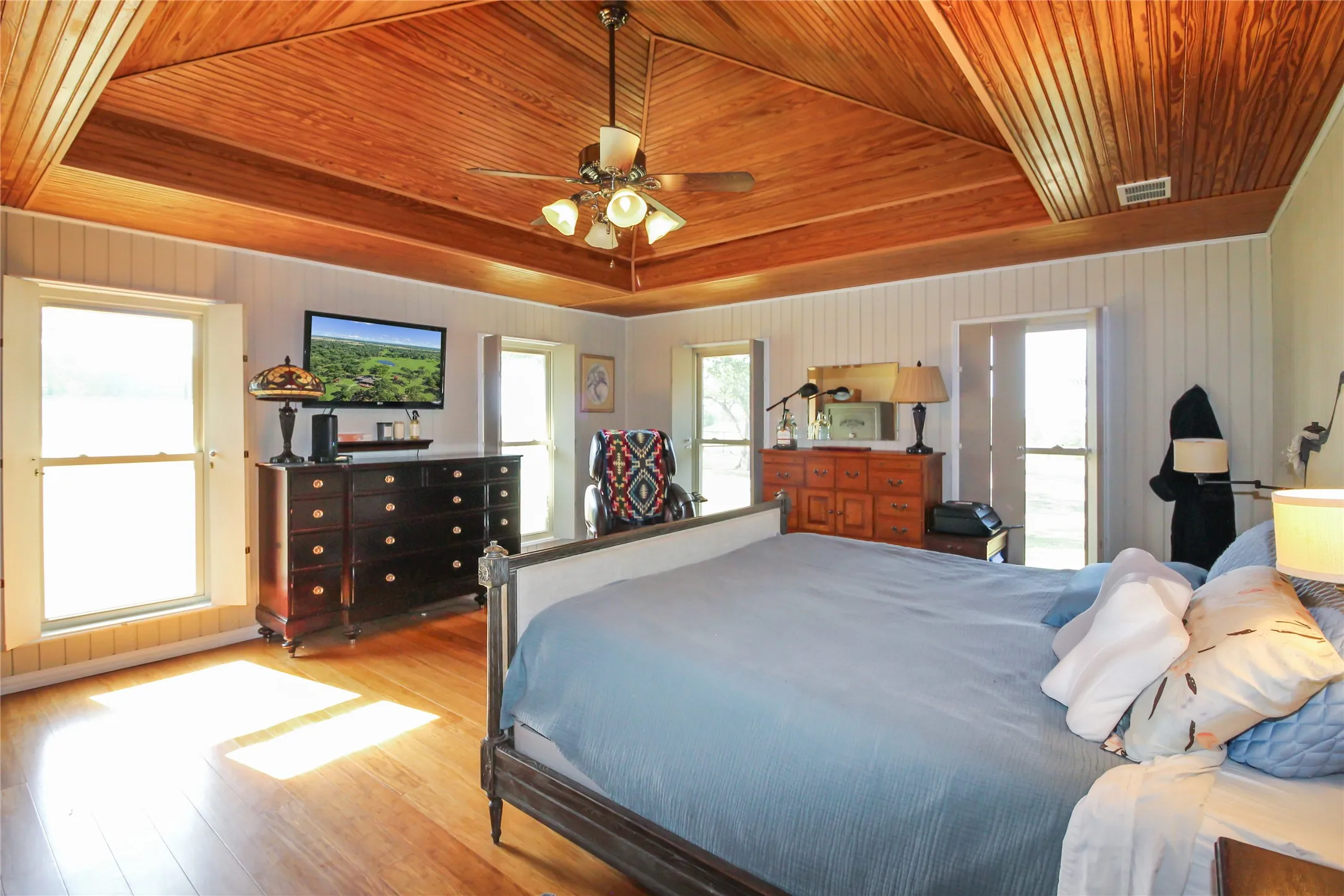 Room featuring a high vaulted wood-paneled ceiling with a central ceiling fan