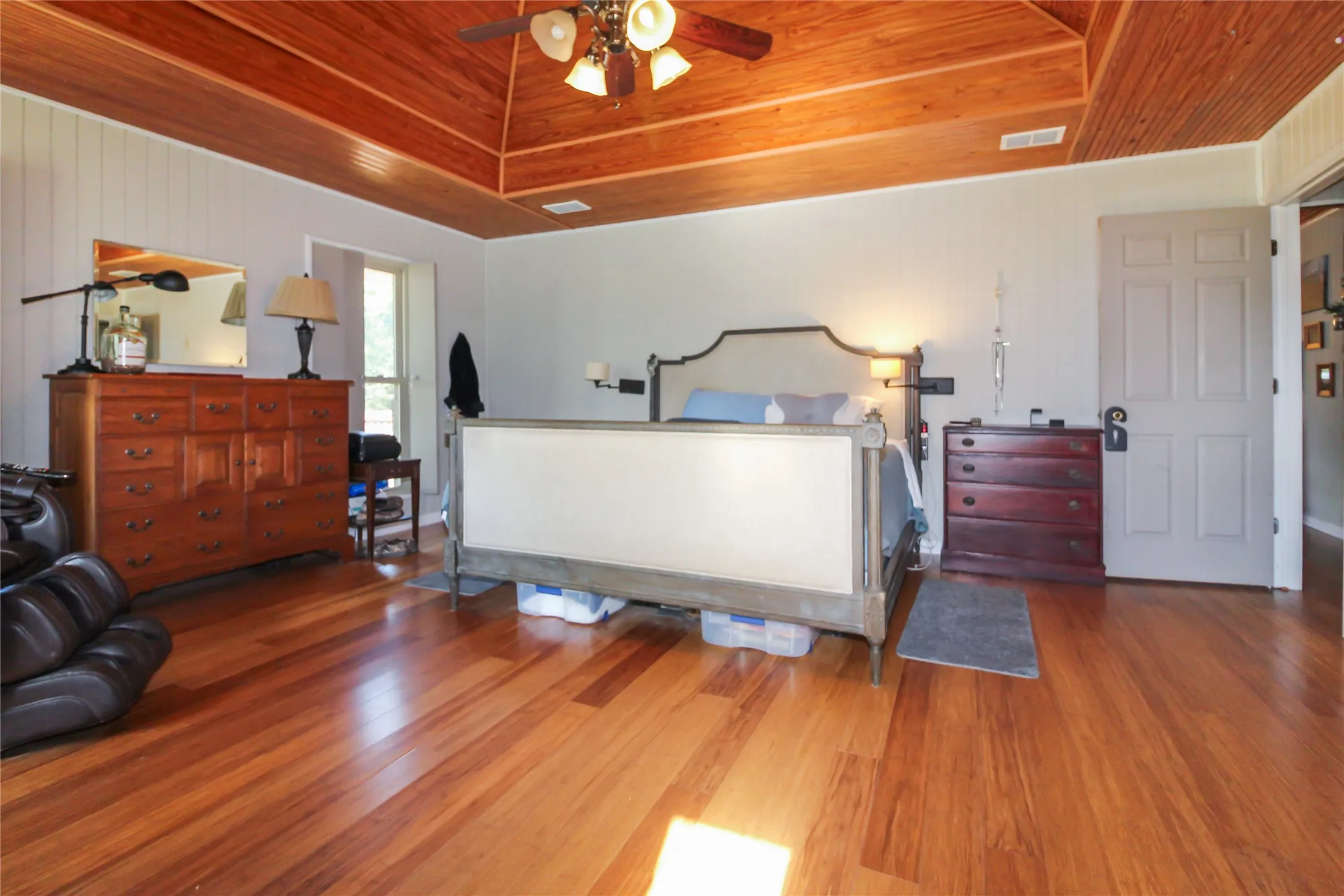 Vaulted wood-paneled ceiling with a central fan light fixture
