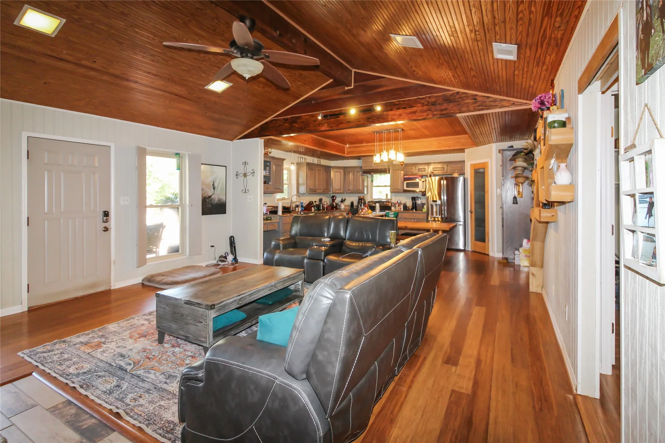 Vaulted wood-paneled ceiling with recessed lighting and a ceiling fan
