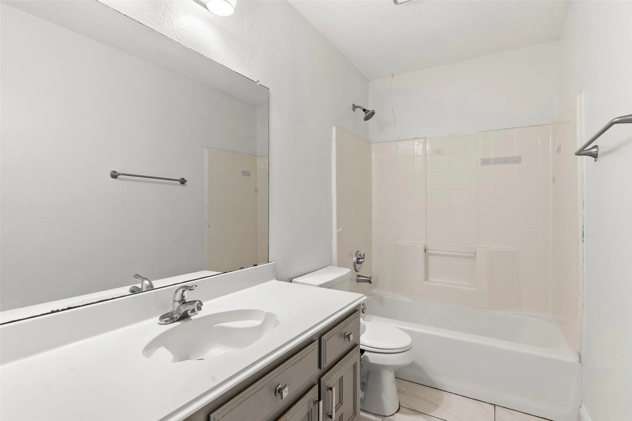 Bathroom featuring a vanity with a white countertop, an integrated sink, and gray cabinetry