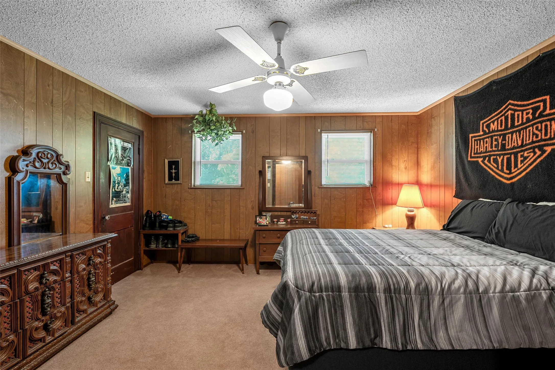 Wood paneling walls frame a room featuring a ceiling fan with integrated lighting