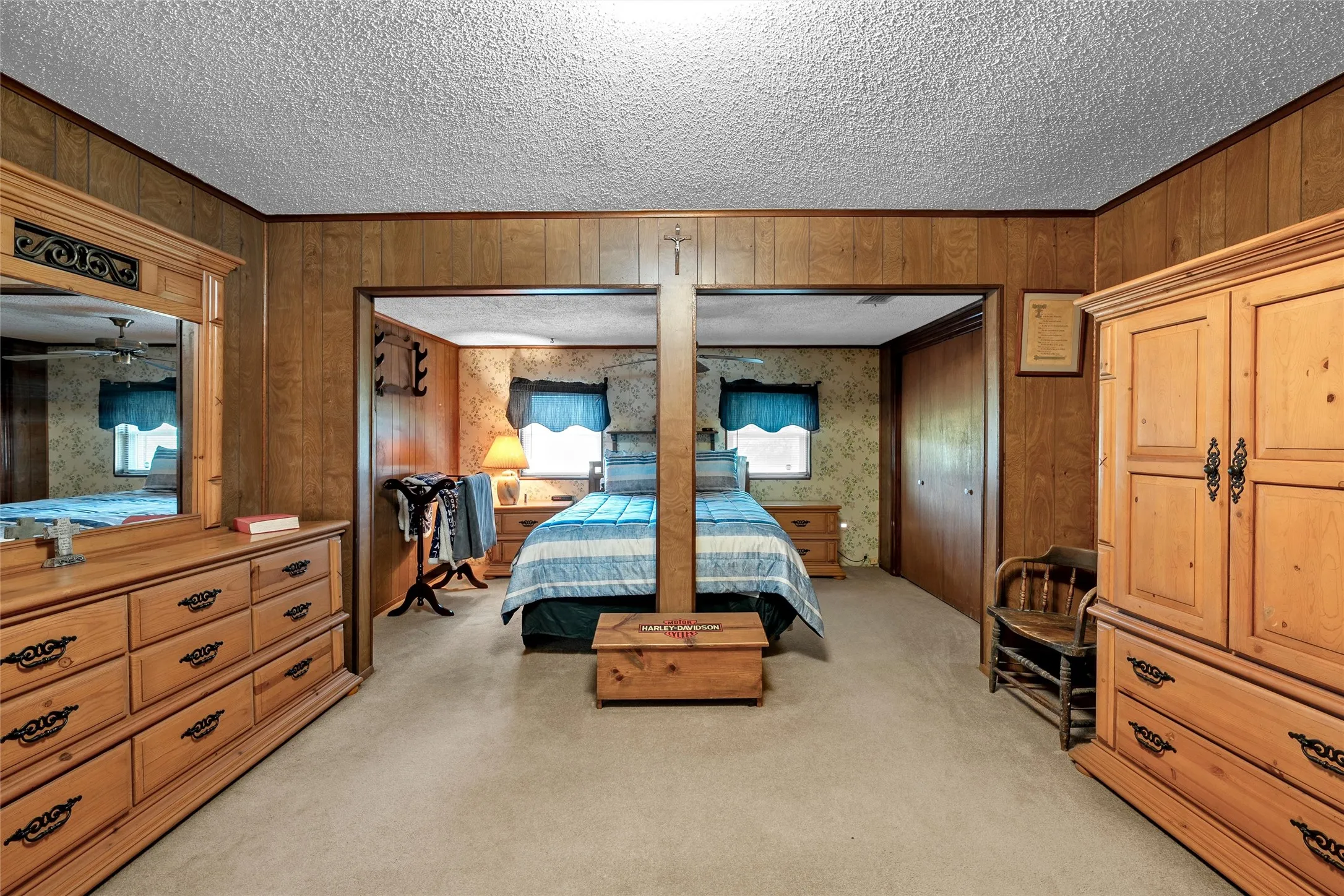 Carpeted room with wood-paneled walls and a textured ceiling