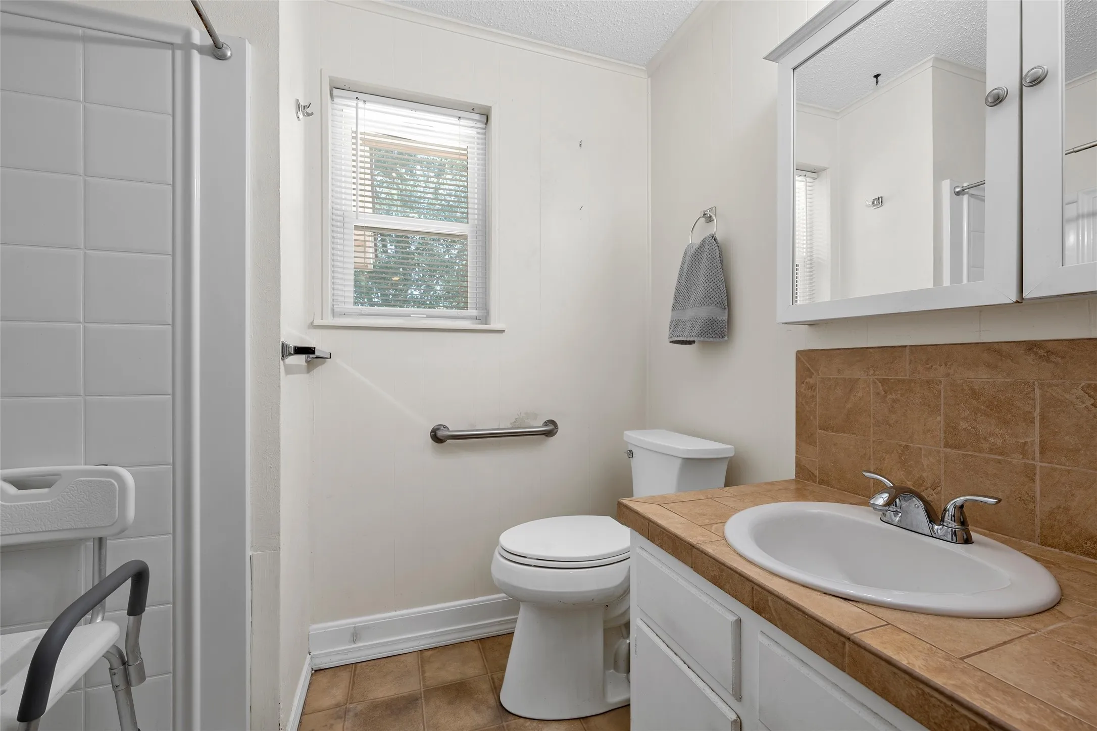 Bathroom vanity with an integrated sink, tile countertop, and medicine cabinet