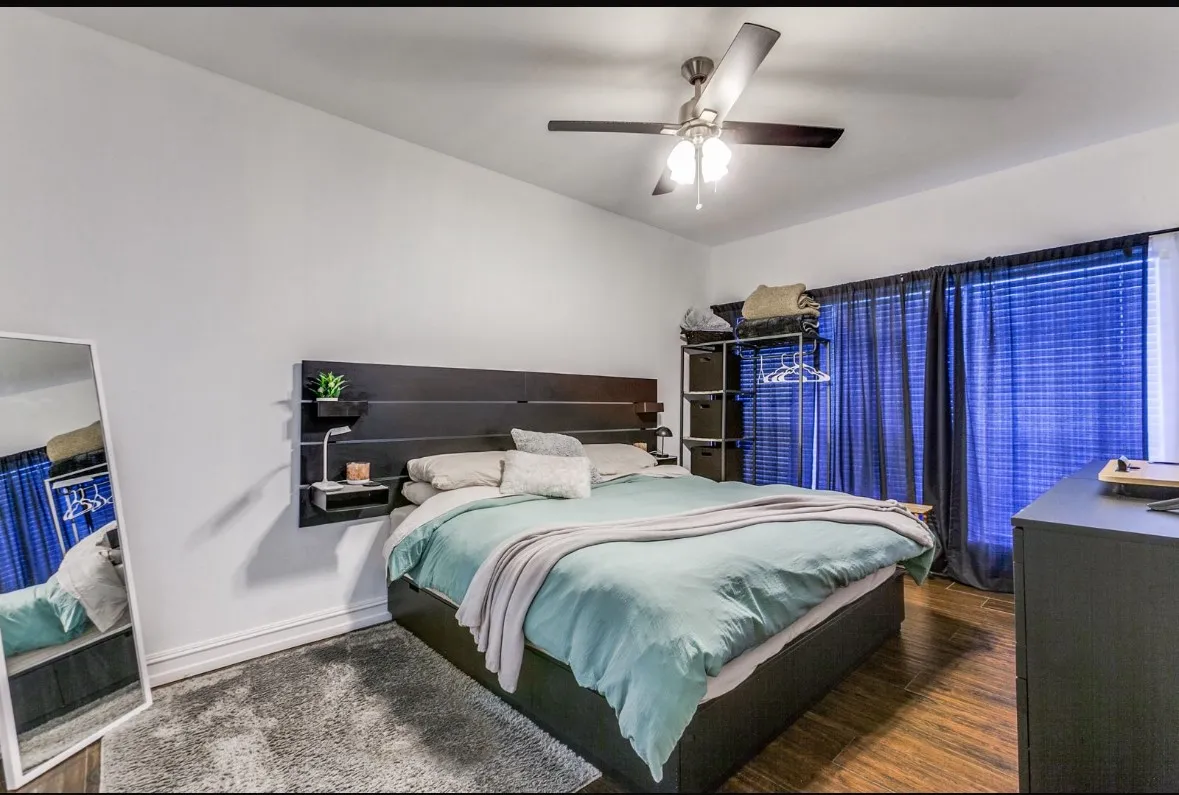 Bedroom with a ceiling fan and wood finished floors