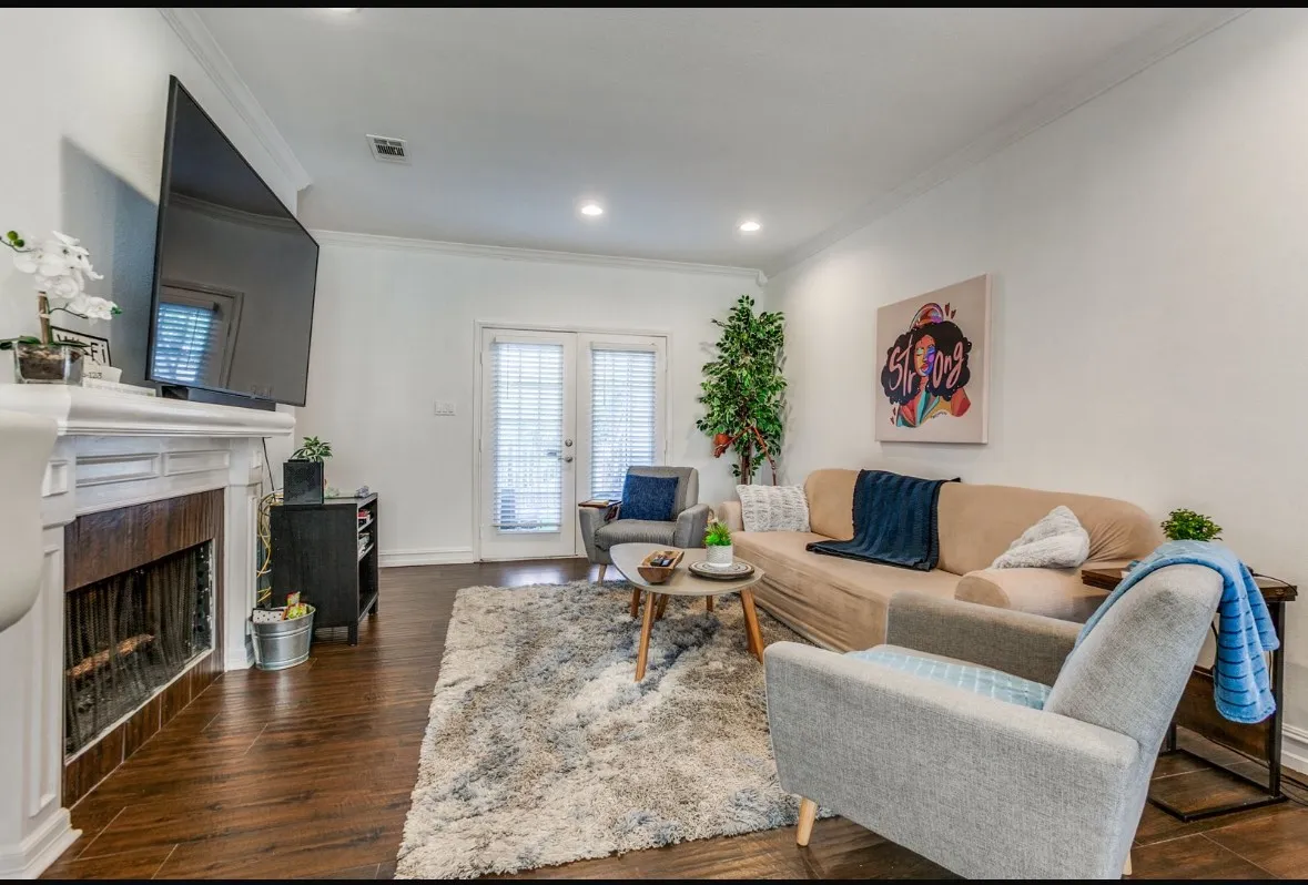 Living area featuring dark wood-style flooring, ornamental molding, a high end fireplace, recessed lighting, and french doors