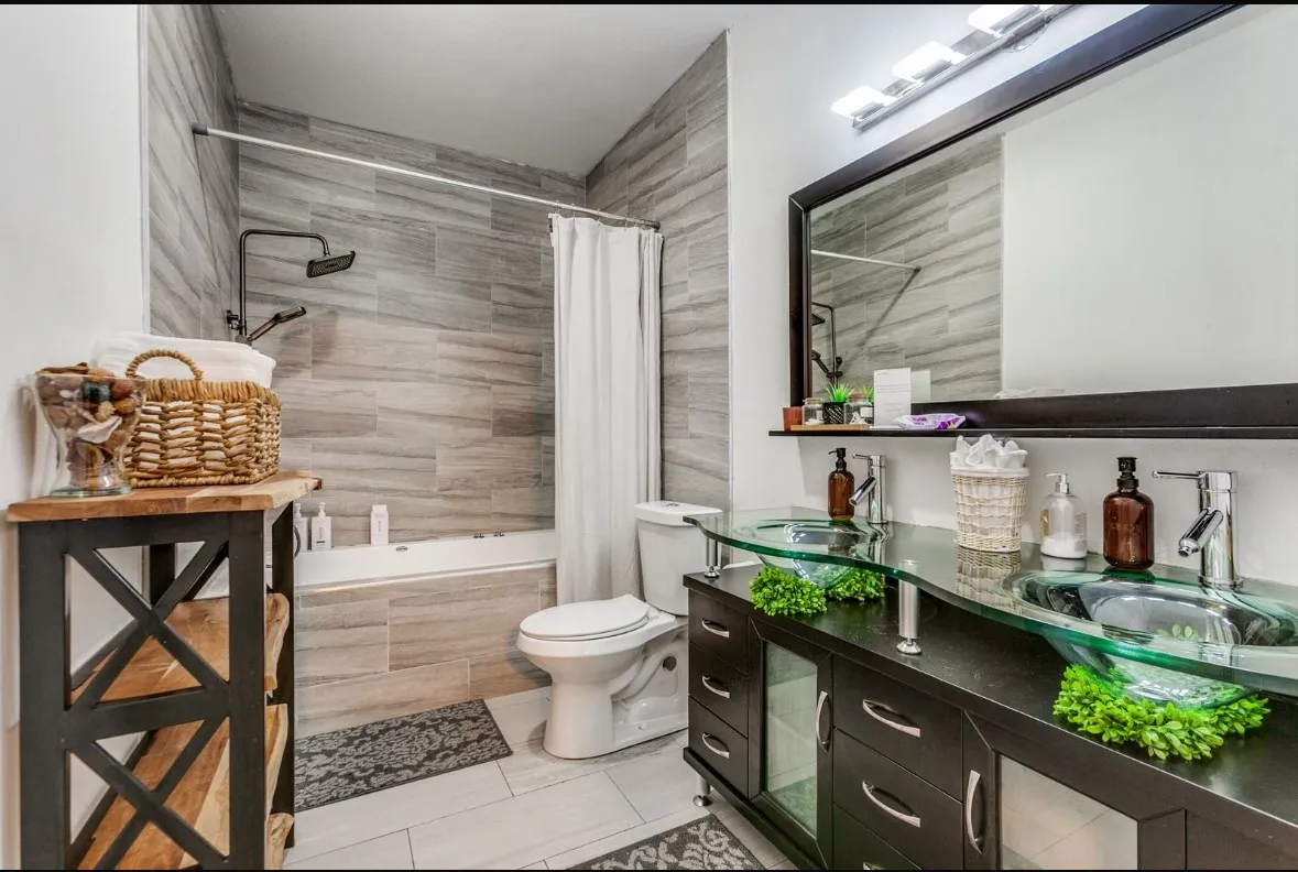 Full bath featuring tiled shower / bath combo, vanity, and light tile patterned floors