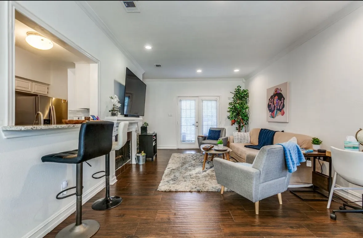 Living room with crown molding, dark wood finished floors, french doors, a fireplace, and recessed lighting