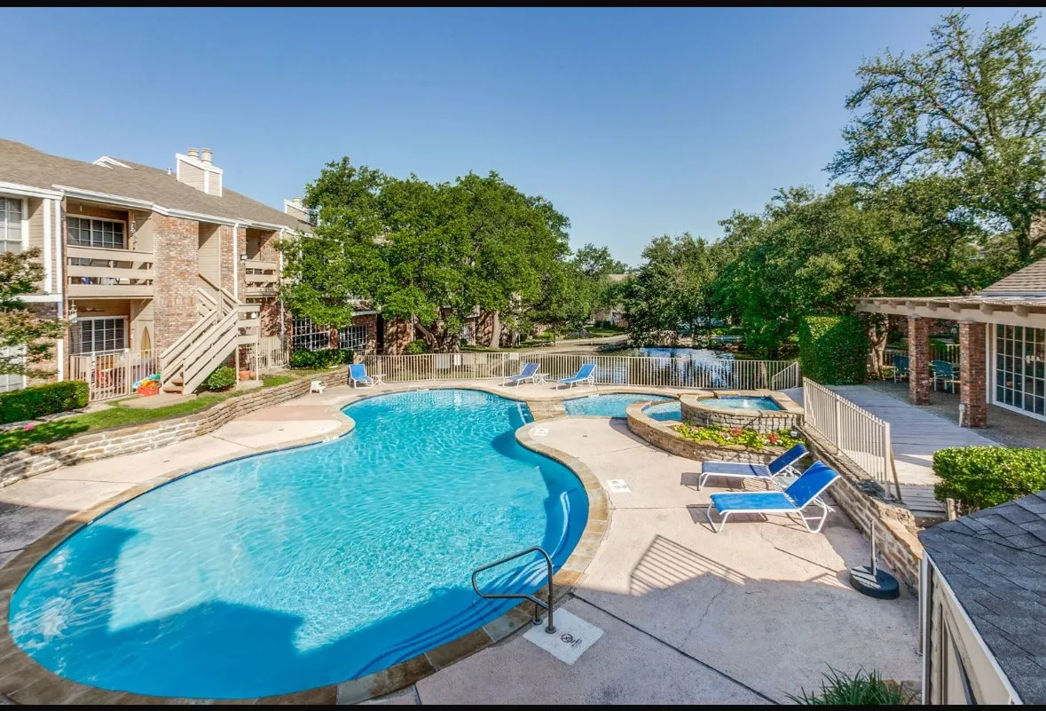 Community pool featuring a hot tub, a patio, and a balcony
