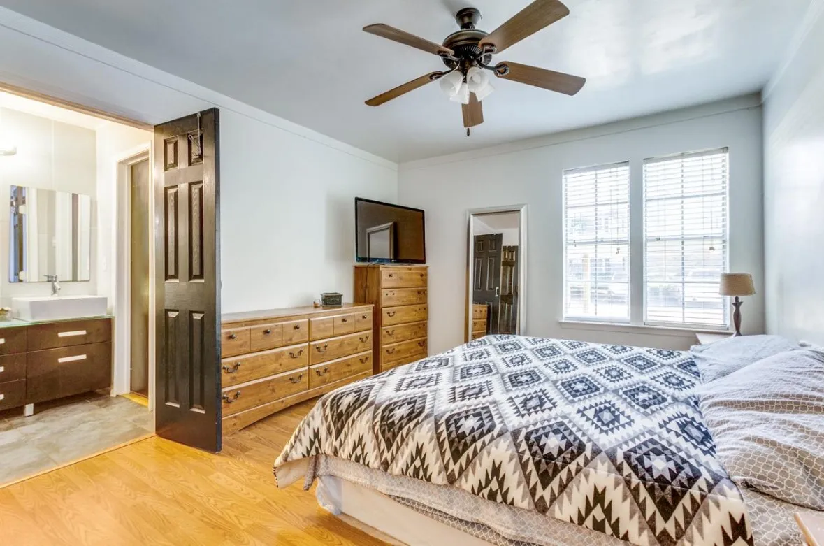 Bedroom featuring light wood finished floors, ornamental molding, and ceiling fan