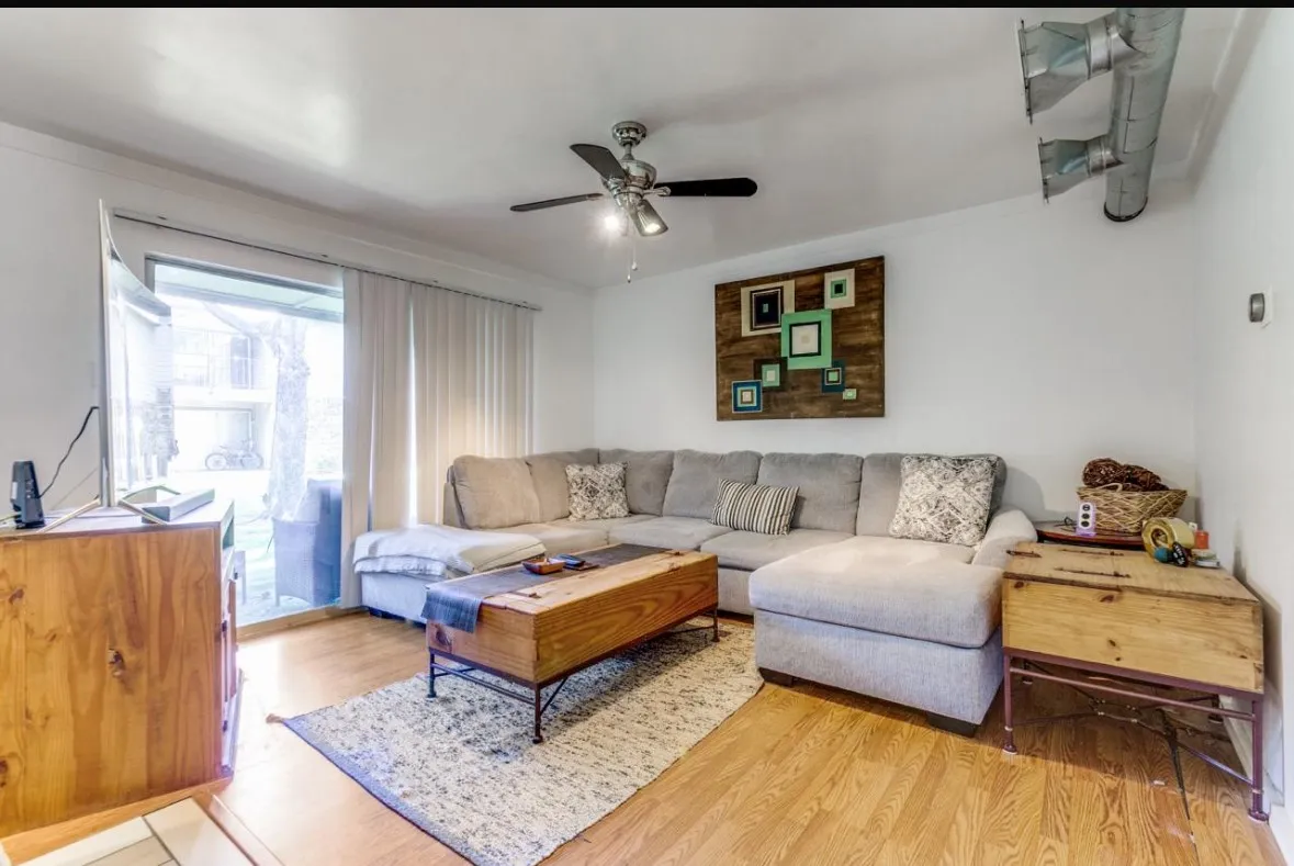 Living room with light wood-style floors and a ceiling fan