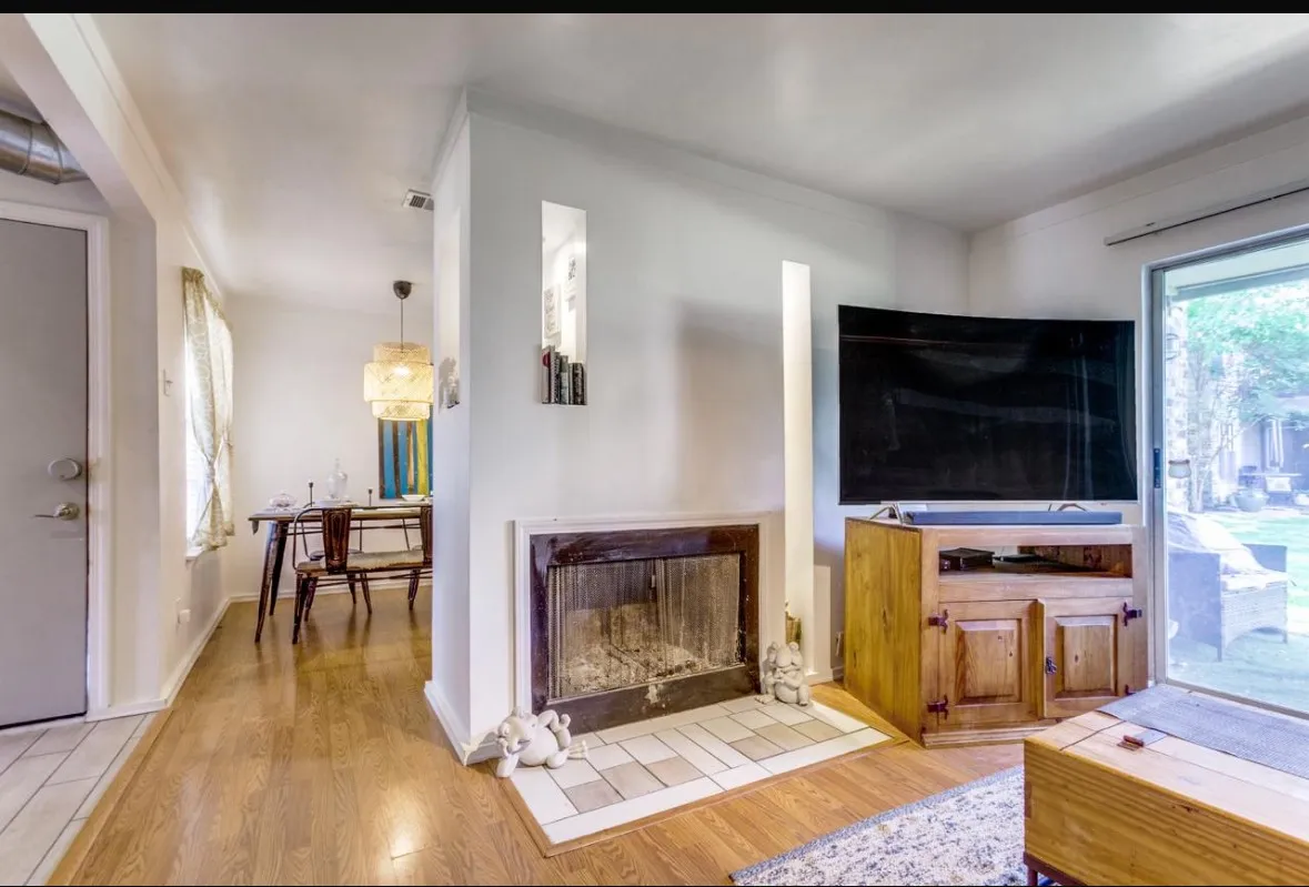 Living area featuring light wood-type flooring, plenty of natural light, and a fireplace