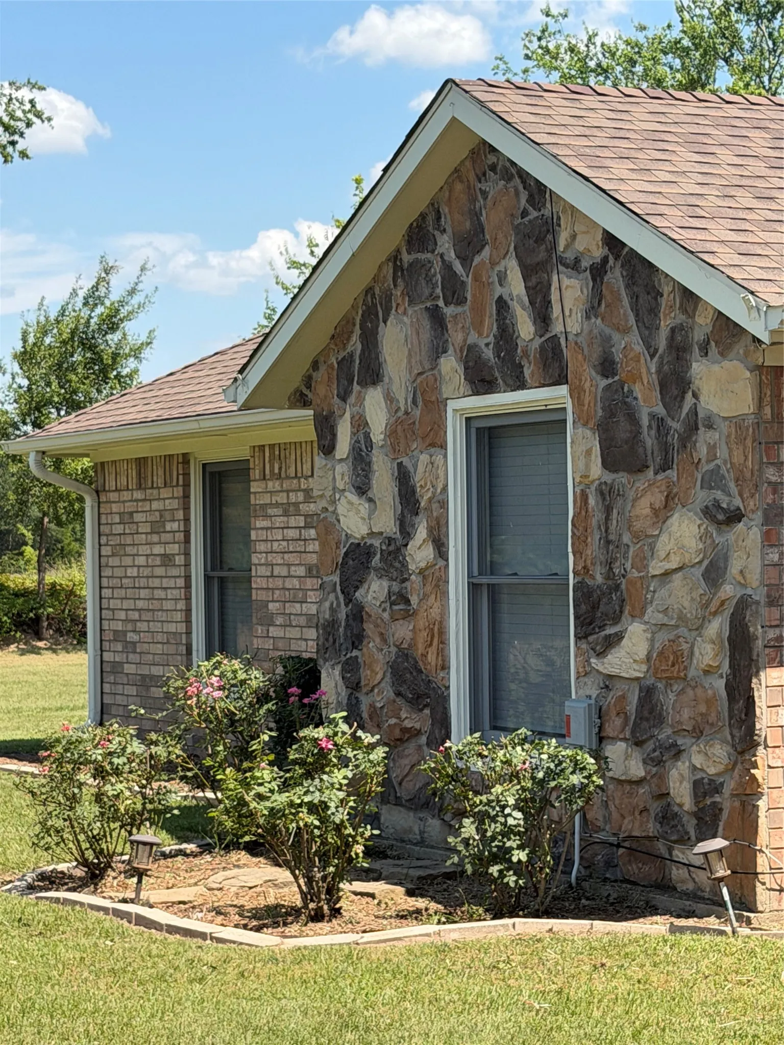 Exterior facade featuring a combination of natural stone veneer and brickwork