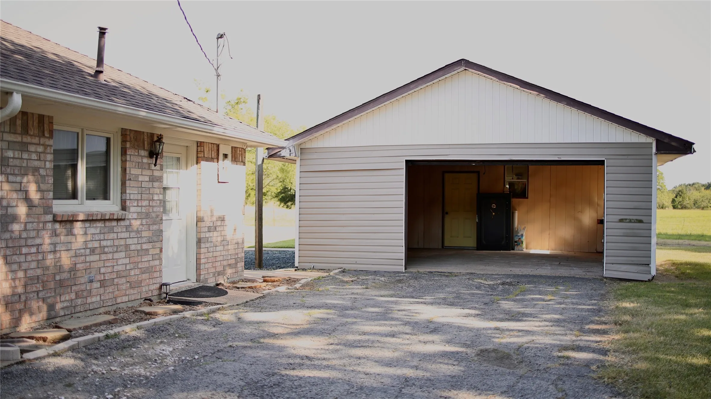 Detached garage structure with a gravel driveway