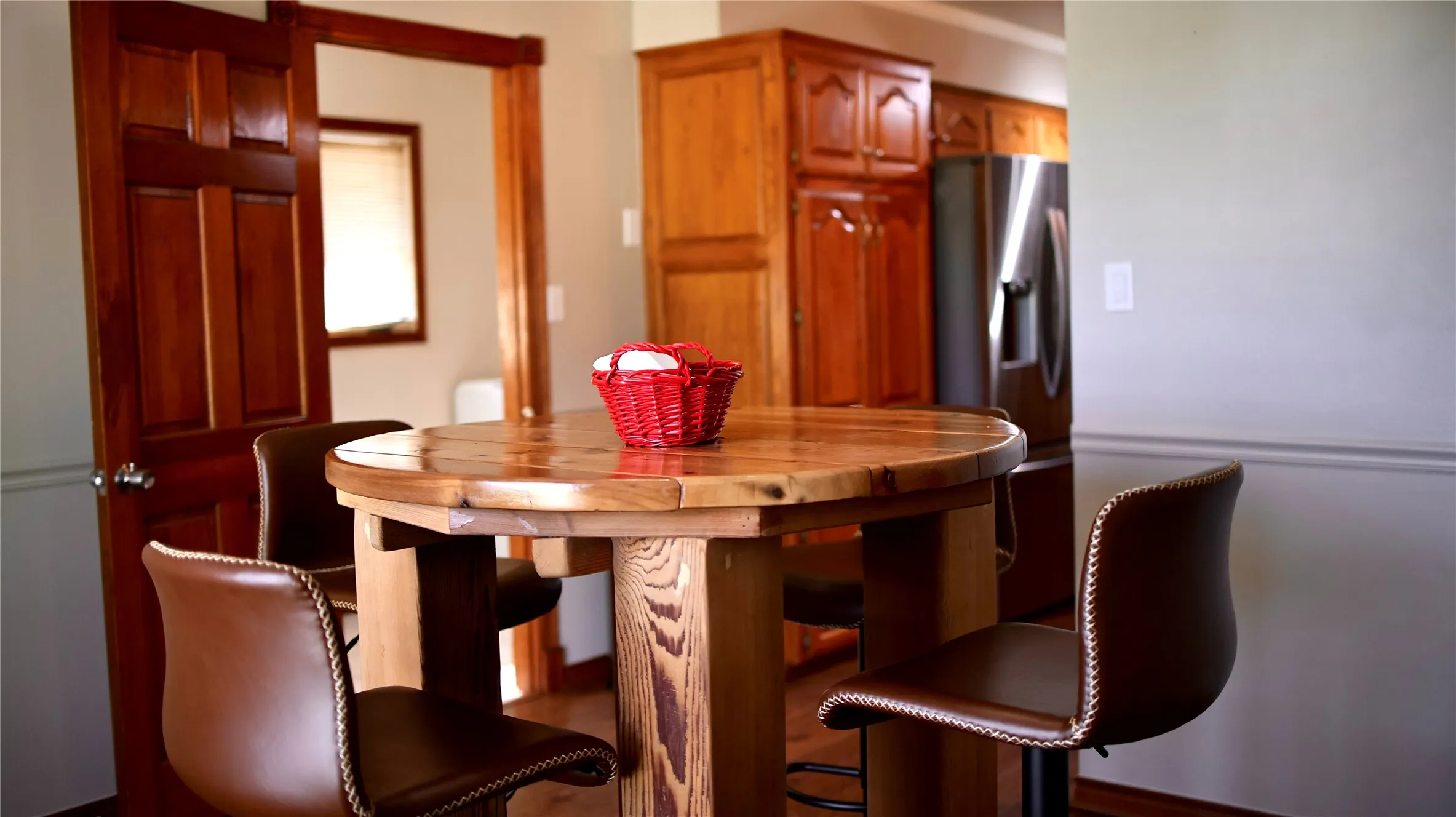 Hardwood flooring throughout, featuring a natural wood-finish dining table