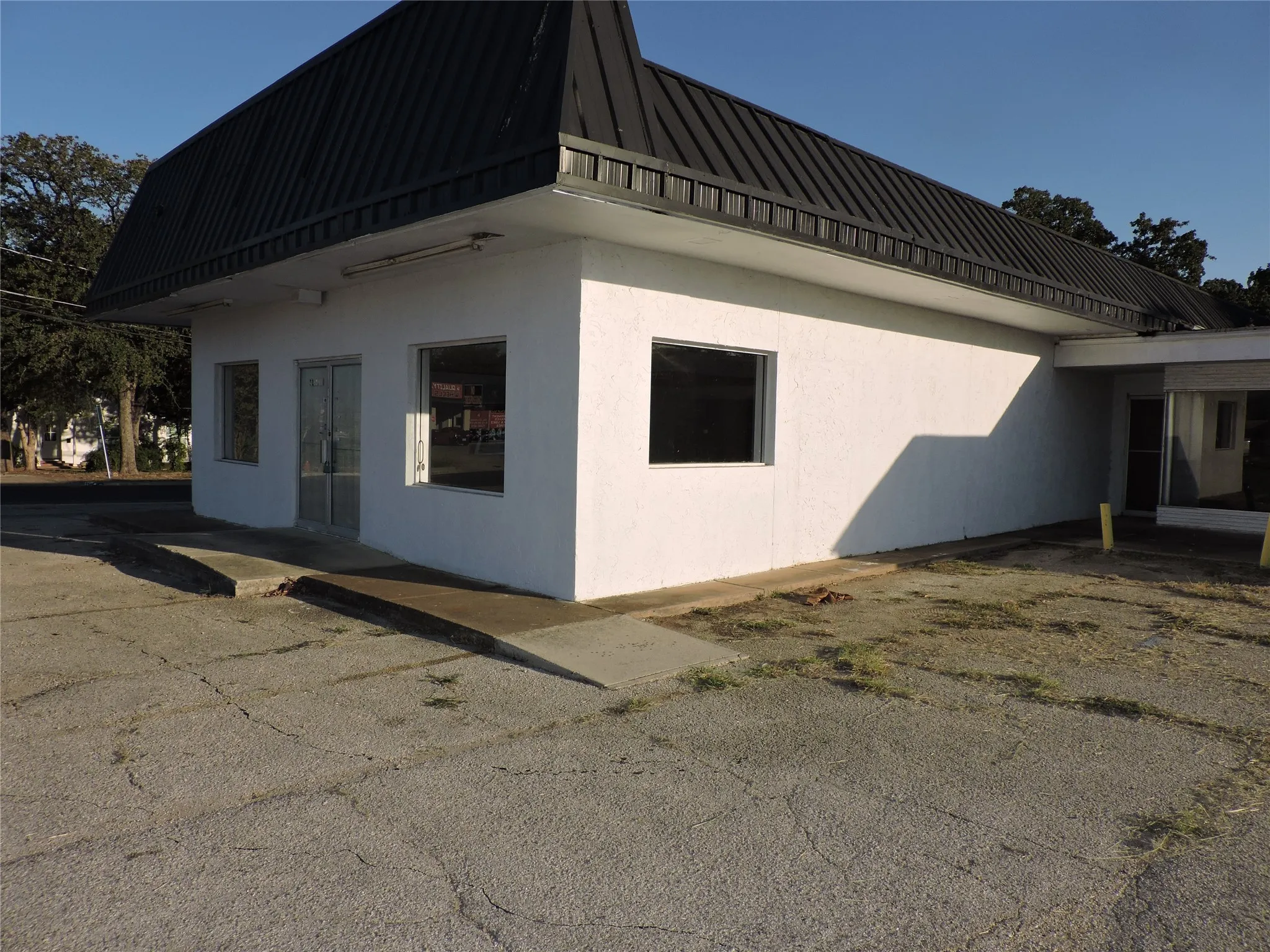 View of side of home with stucco siding, a metal roof, and a patio