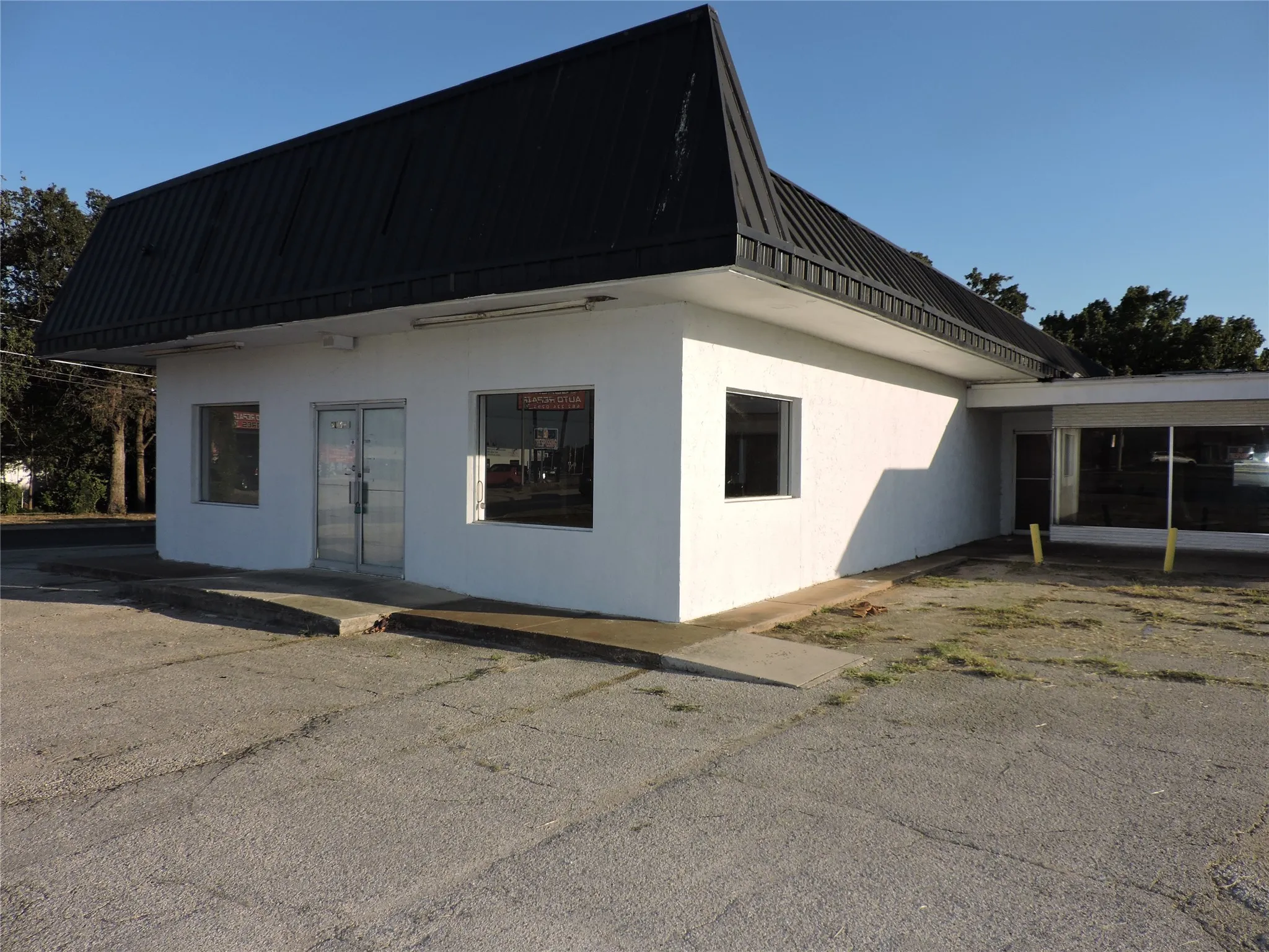 View of property exterior with stucco siding, a metal roof, and french doors