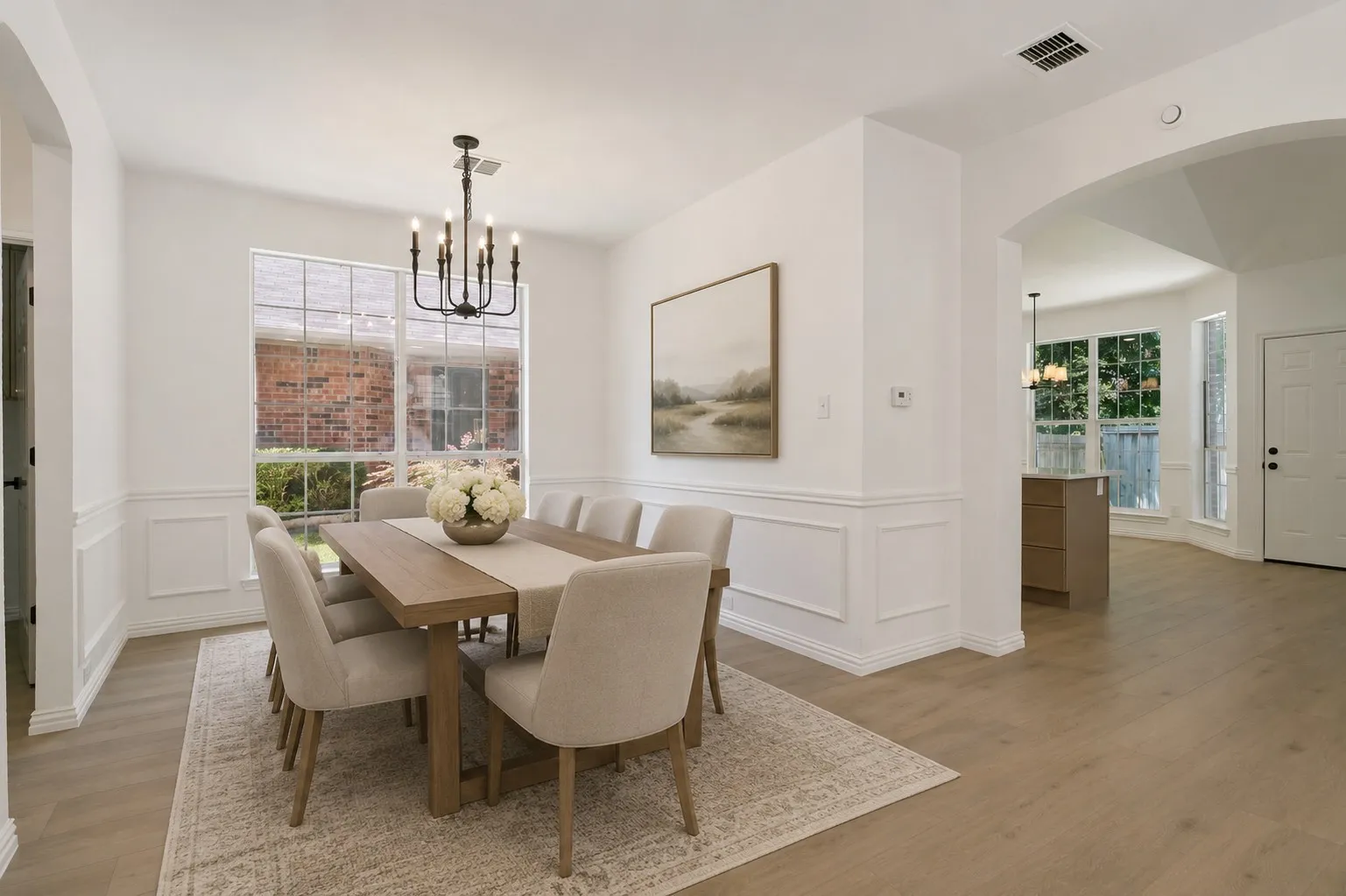 Formal dining area featuring wainscoting, wood-finish flooring, and a contemporary chandelier