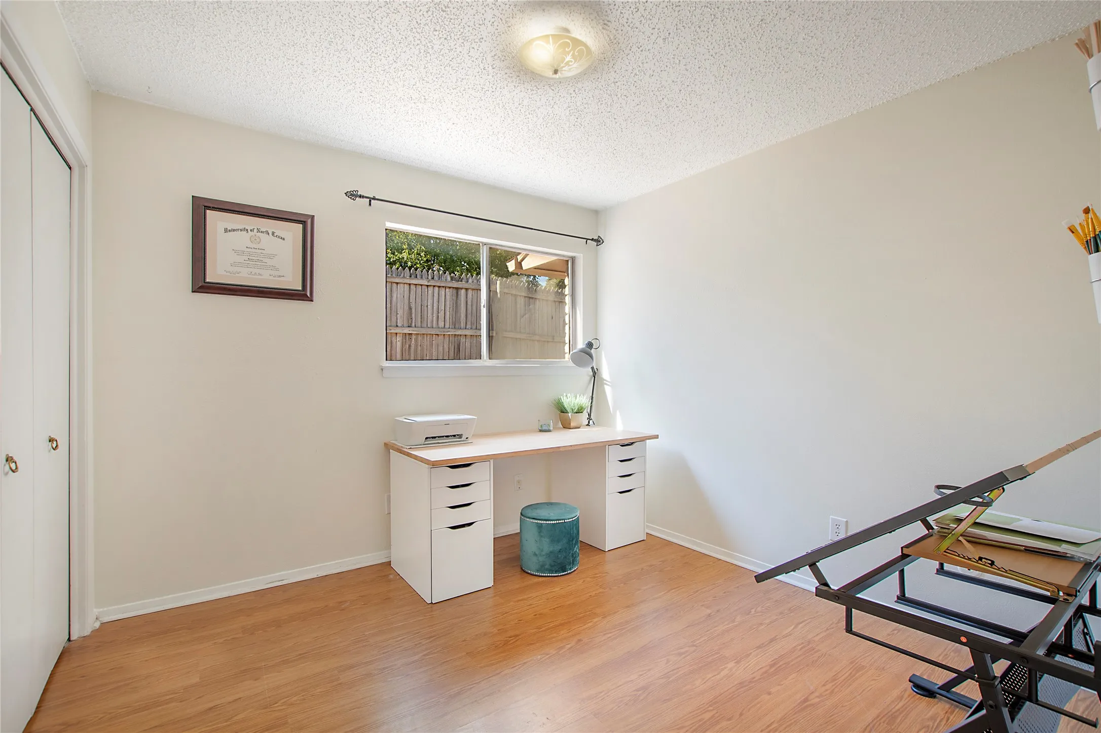 Room featuring wood-finish flooring, a window with a rod, and a ceiling-mounted light fixture
