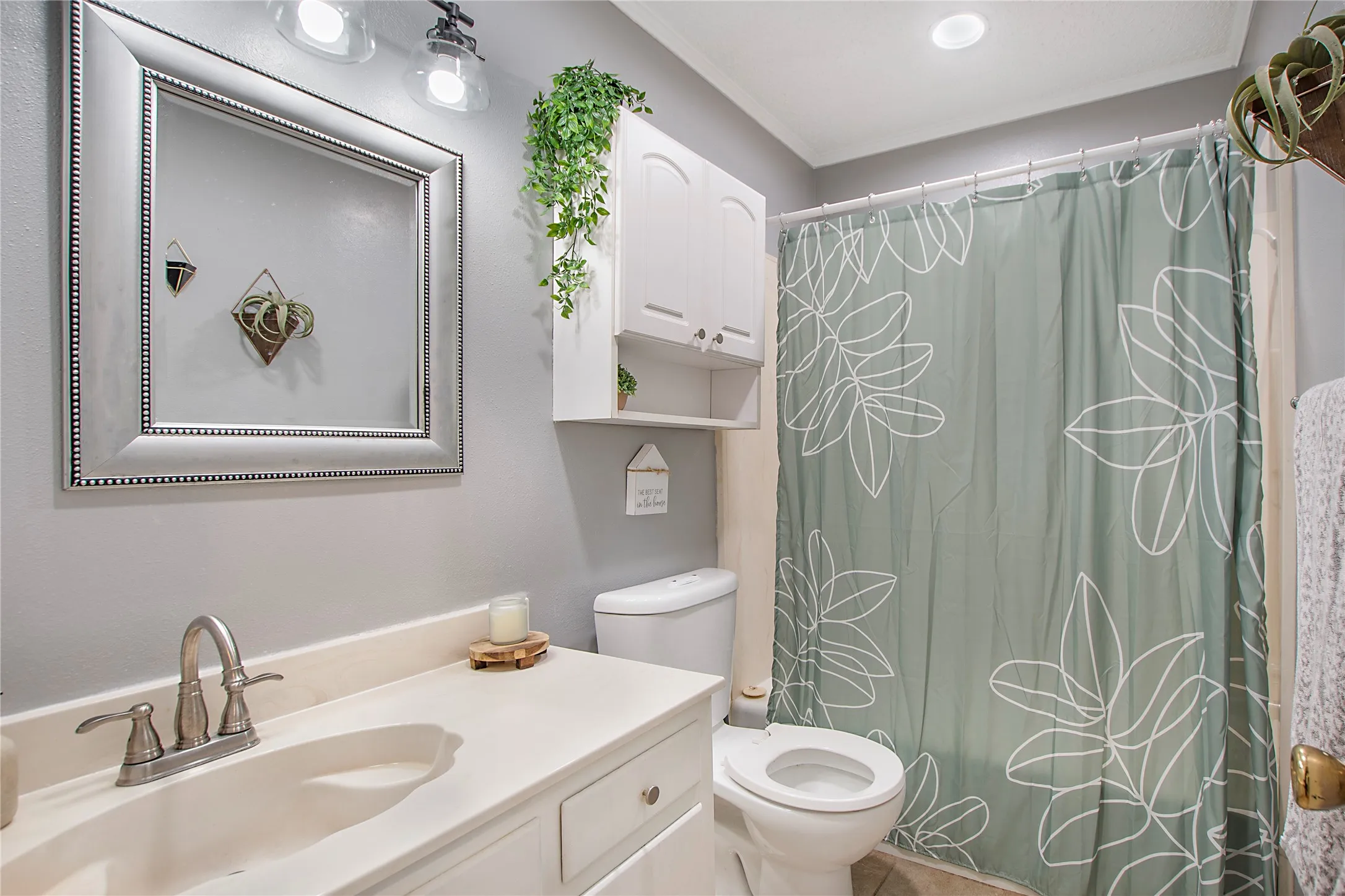 Bathroom featuring a white vanity with integrated sink, brushed nickel faucet, and a large framed mirror