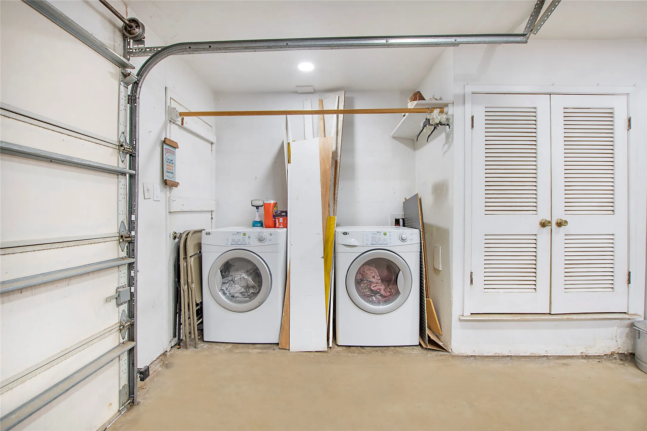 Utility area featuring dual laundry machines, louvered bi-fold doors, and recessed lighting