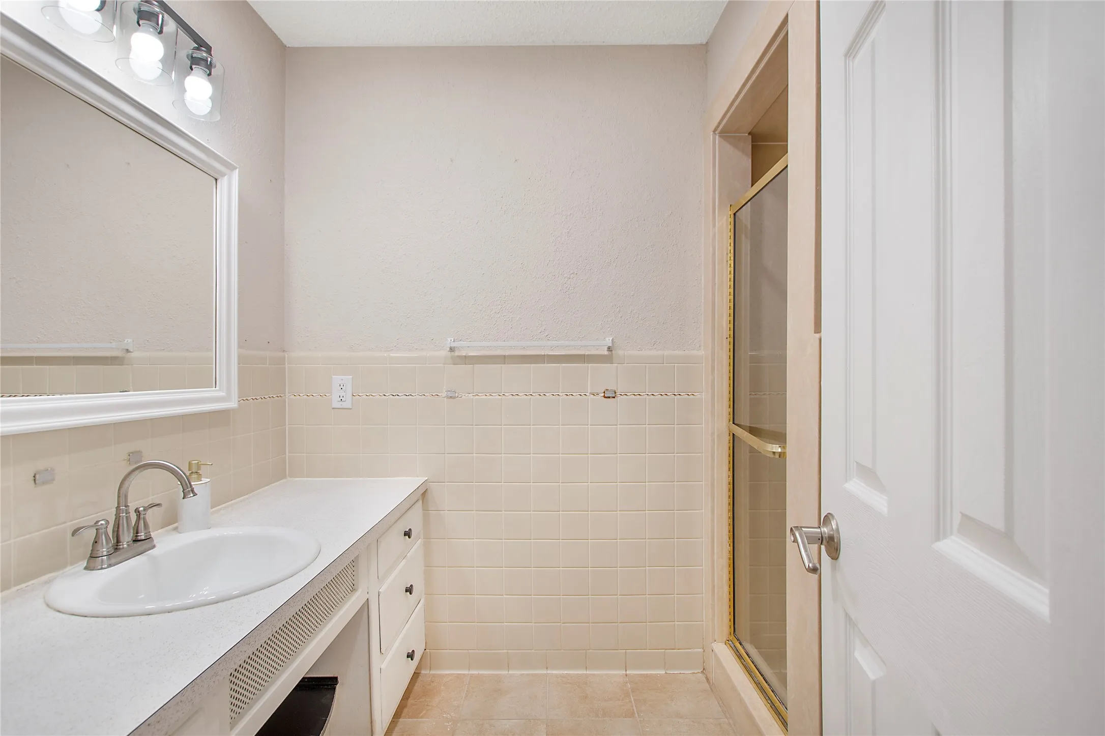 Bathroom vanity with an integrated sink, brushed nickel faucet, and a wall-mounted mirror