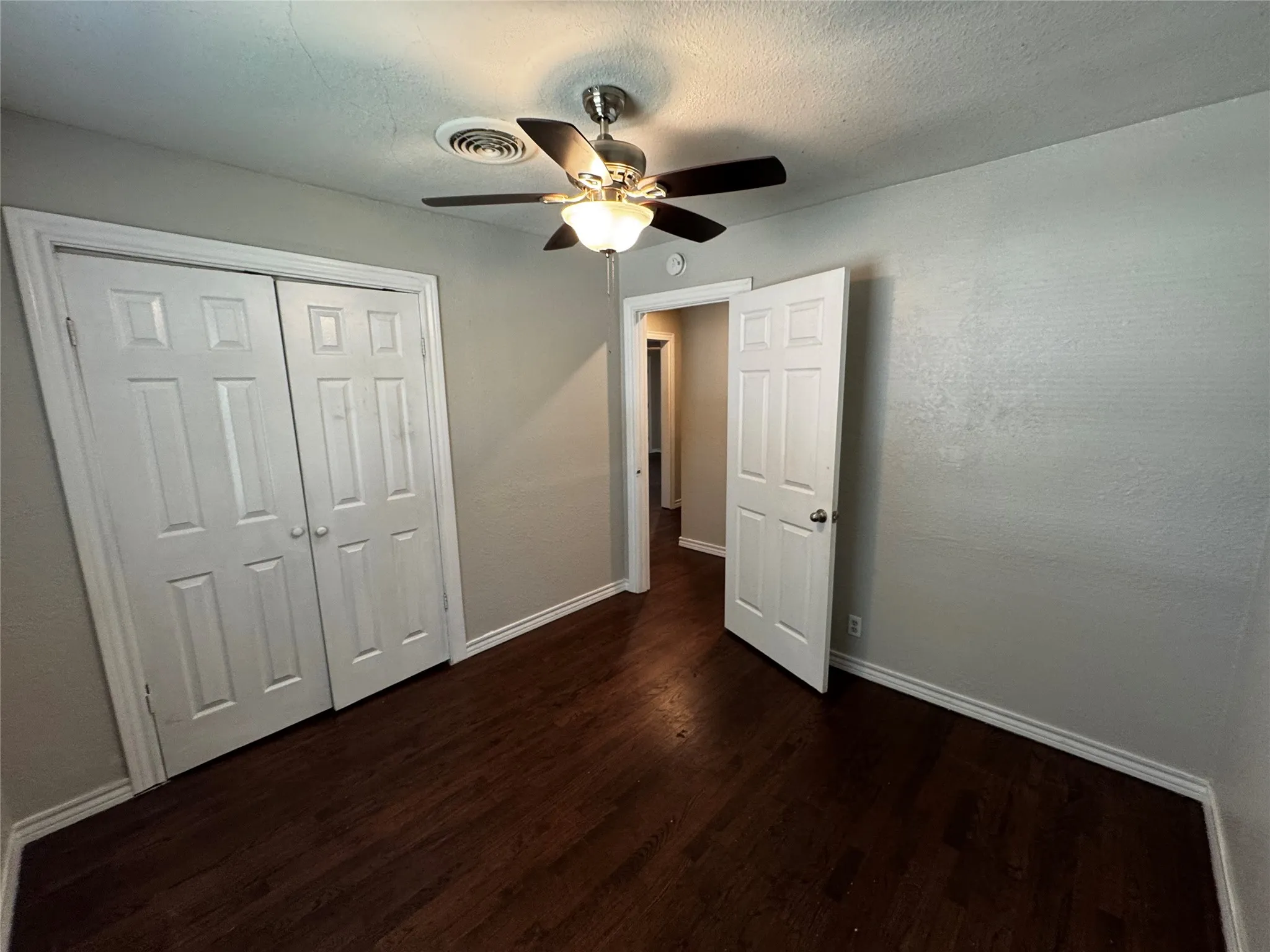 Room featuring wood-finish flooring, neutral wall paint, and white trim