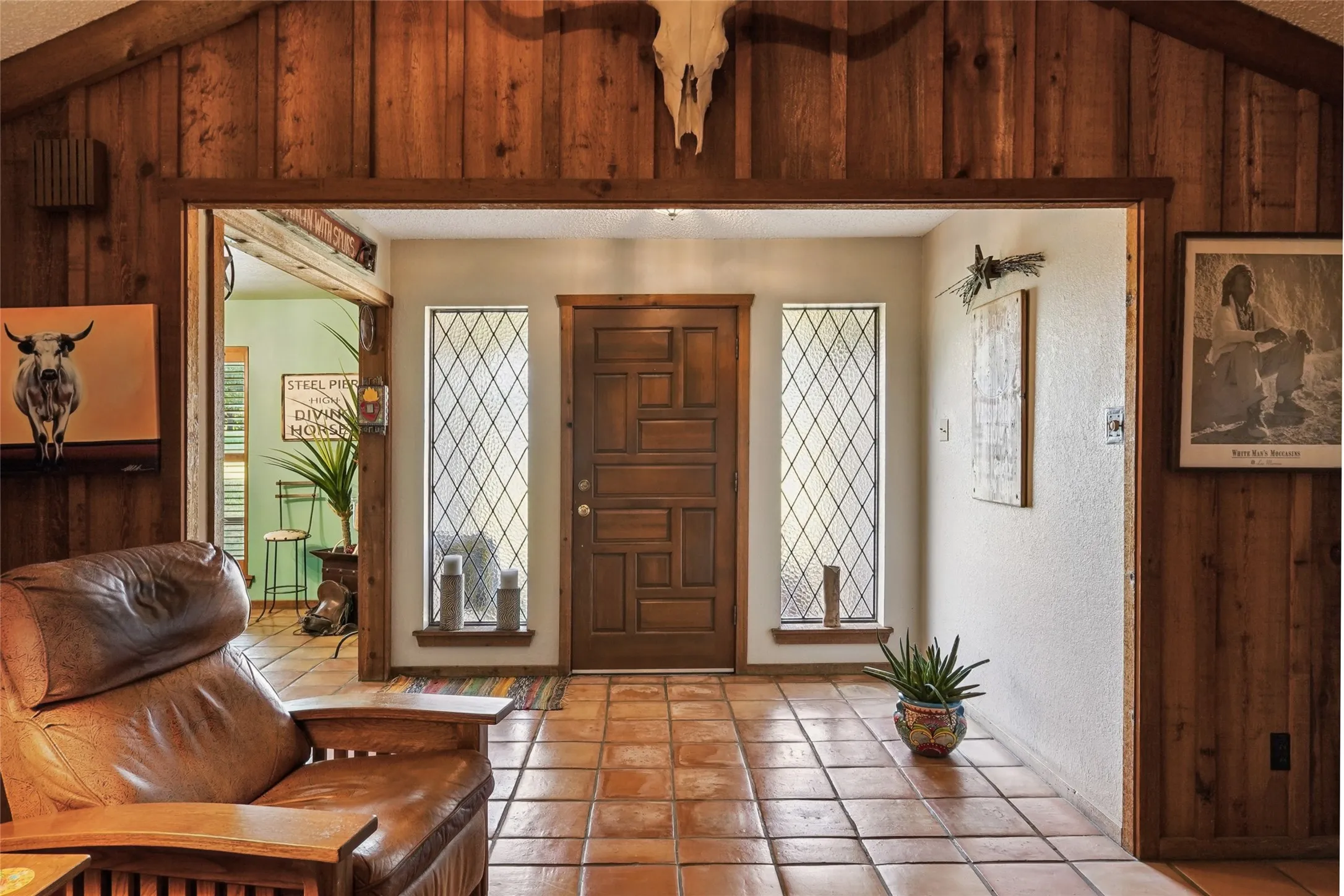 Entryway featuring wood-paneled walls and a wood-finish door with geometric paneling