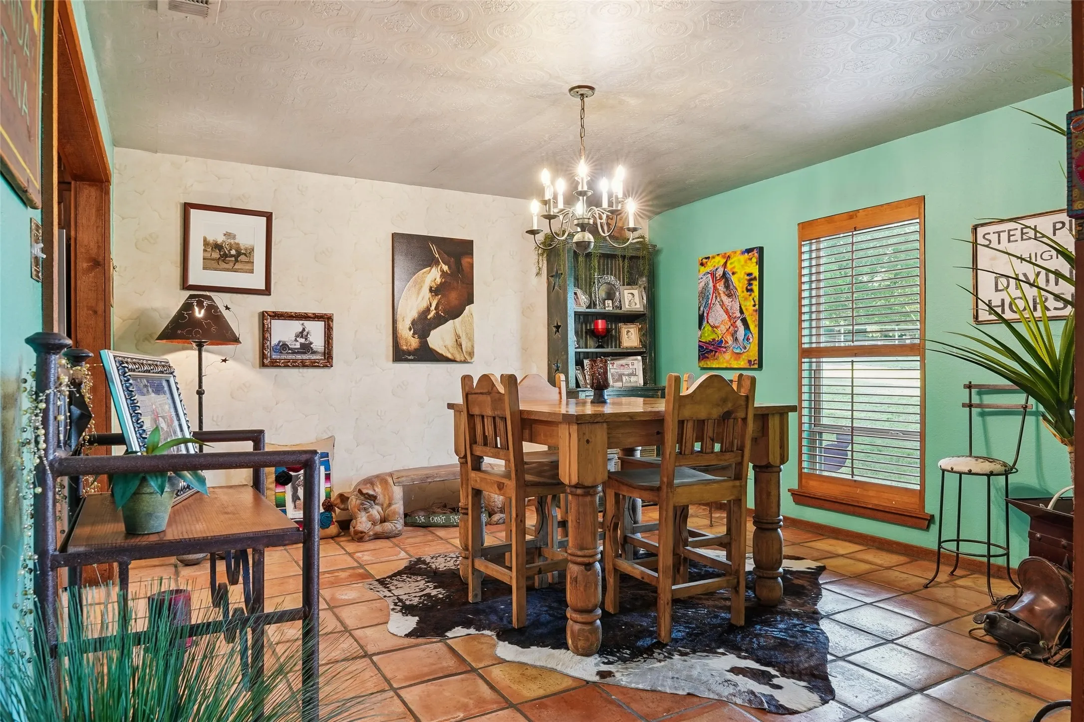 Dining space featuring tile flooring, a multi-light chandelier, and wood-framed windows
