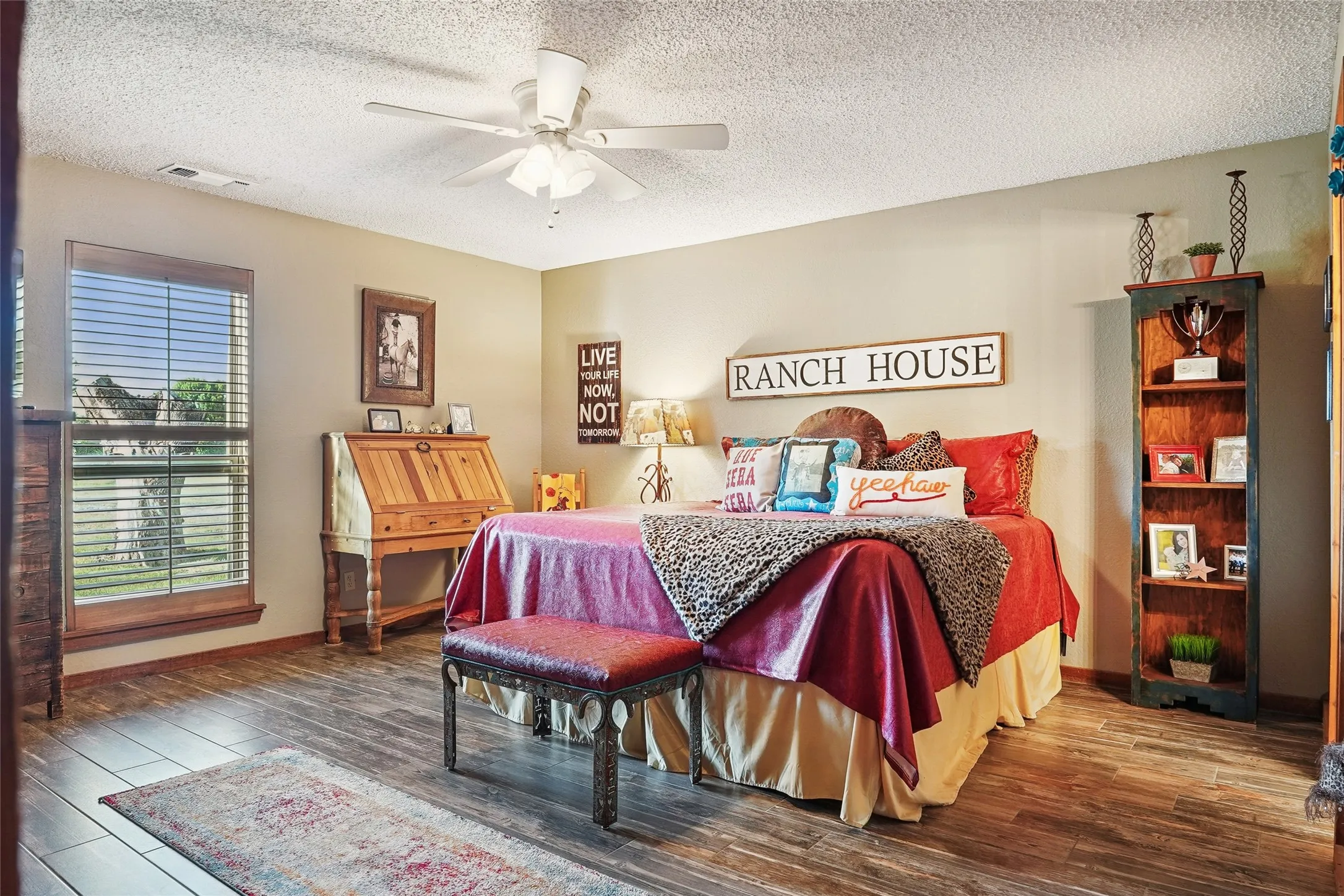 Spacious room featuring wood-finish flooring, neutral-toned walls, and a ceiling fan