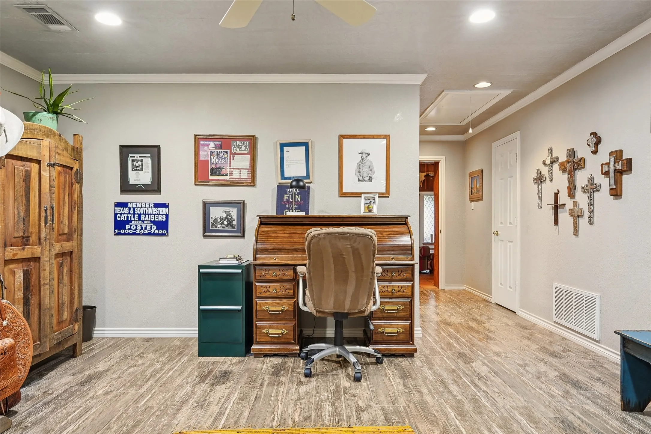 Spacious interior area featuring wood-finish flooring, recessed lighting, crown molding, and white trim