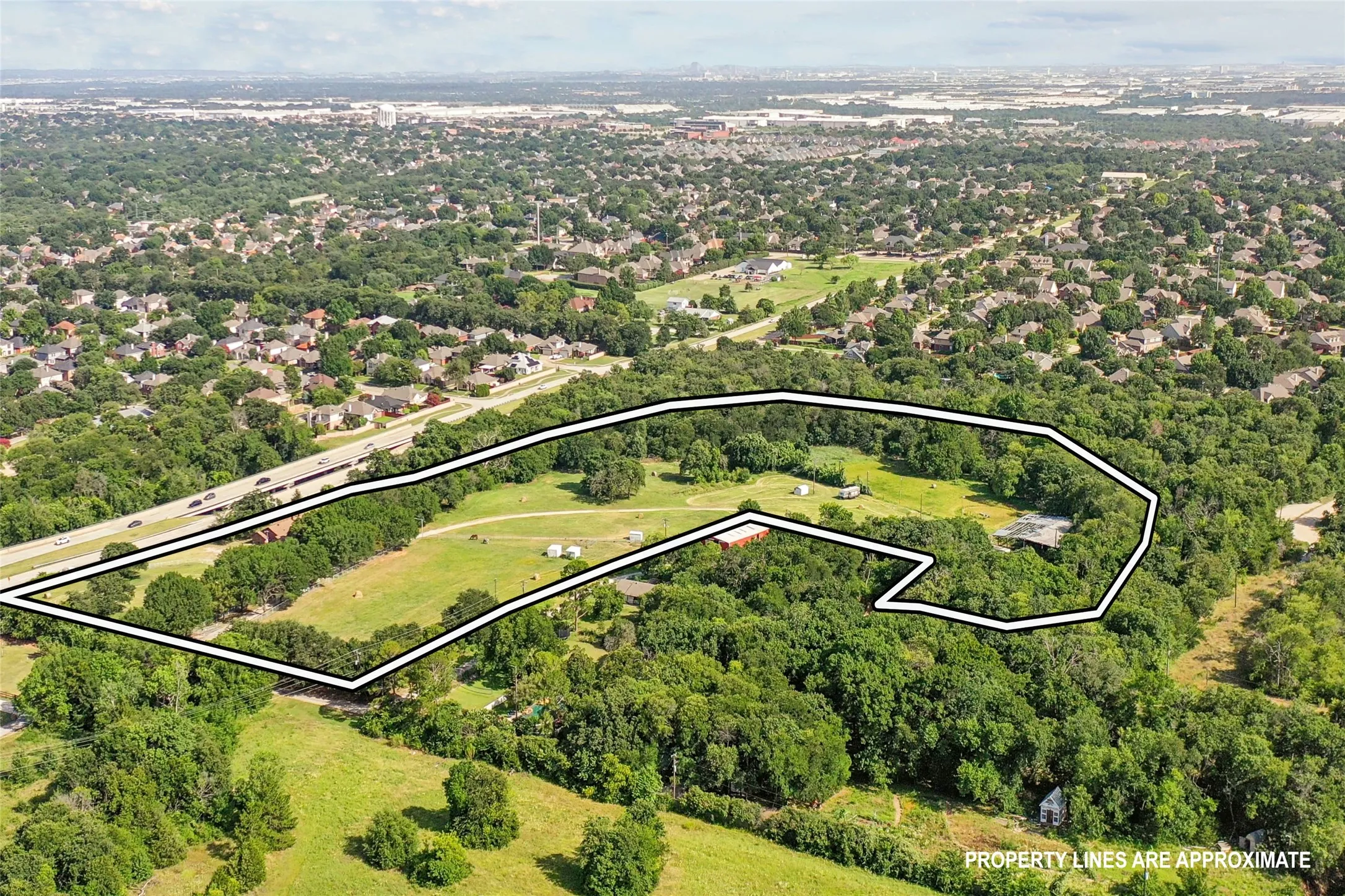 Expansive property featuring a mix of open fields and dense tree coverage