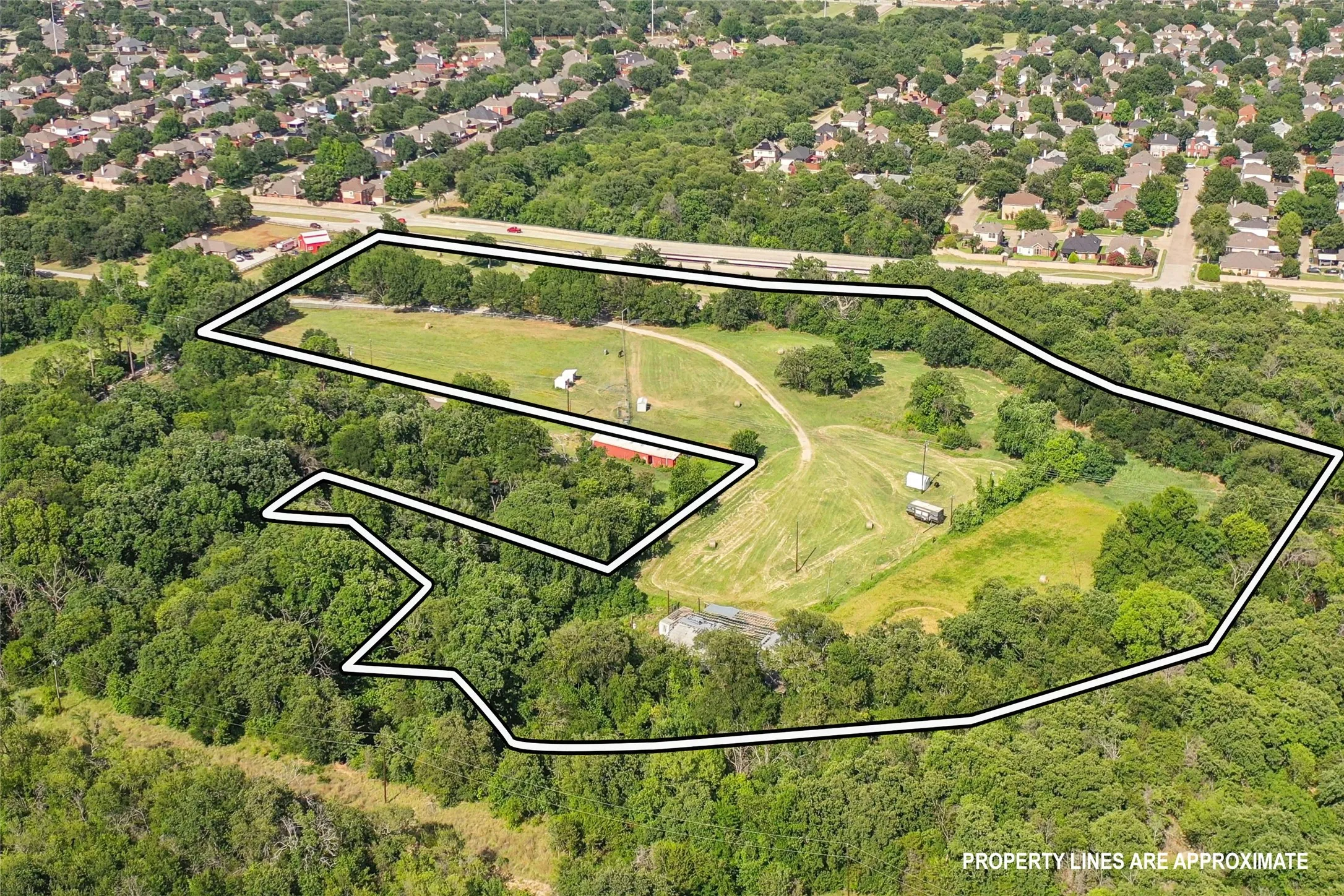 Expansive land parcel featuring a mix of cleared areas and mature tree coverage