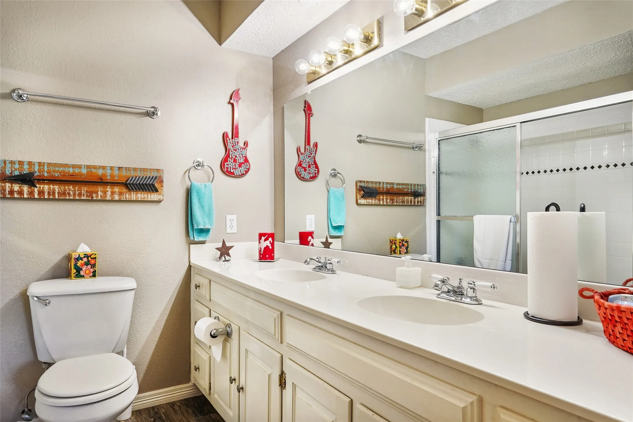Bathroom featuring a double vanity with integrated sinks, white cabinetry, and a large mirror