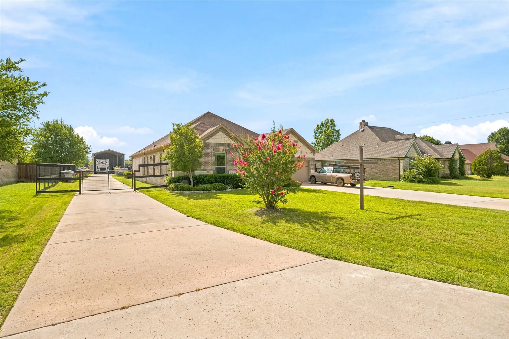 Concrete driveway leading to a gated entry and a covered structure