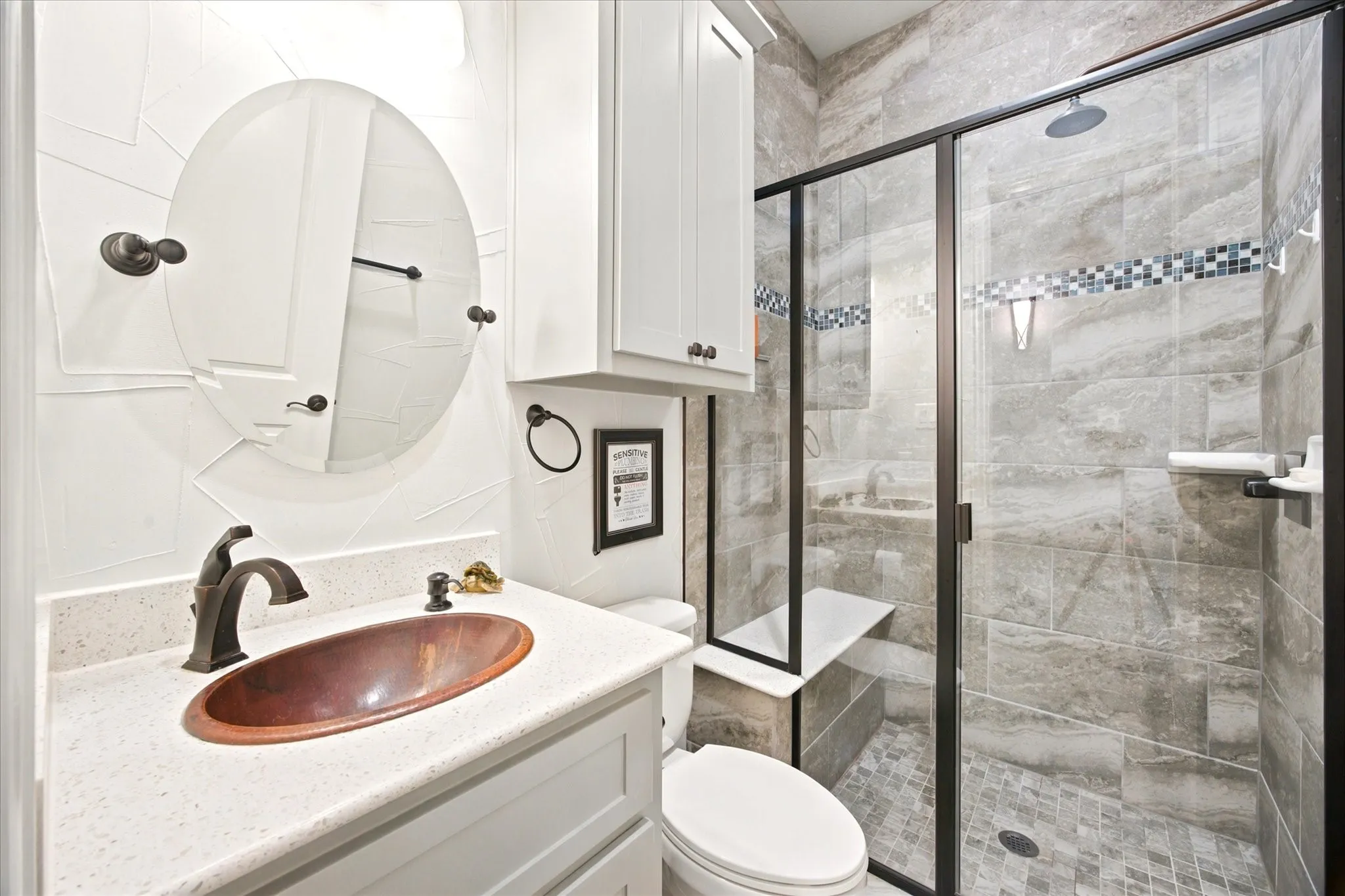 Bathroom featuring a copper vessel sink, quartz-finish countertop, and white shaker-style cabinetry