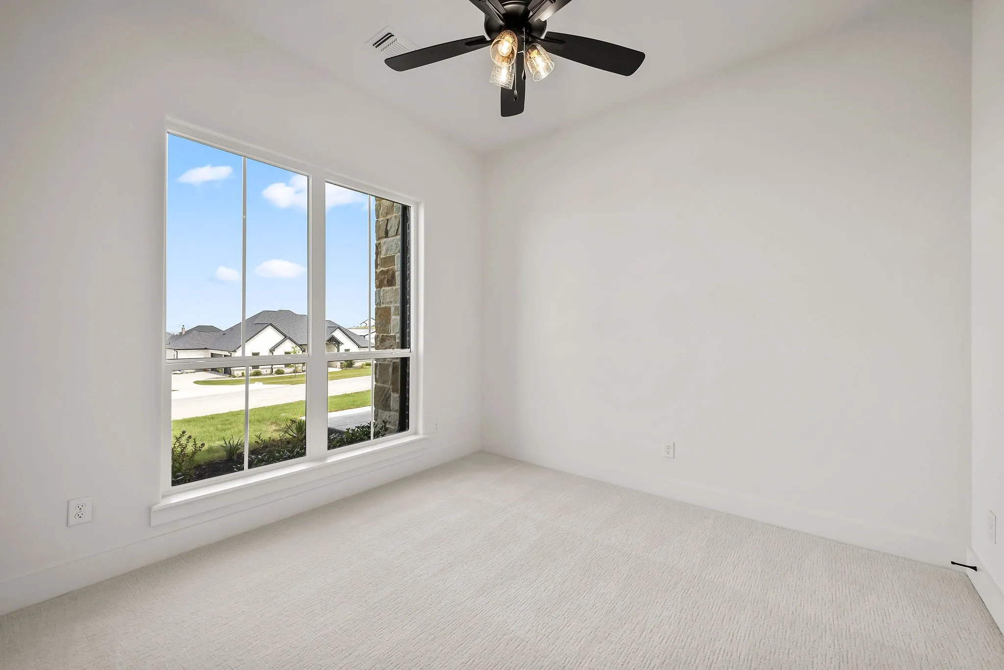 Bright room with a large window and a ceiling fan