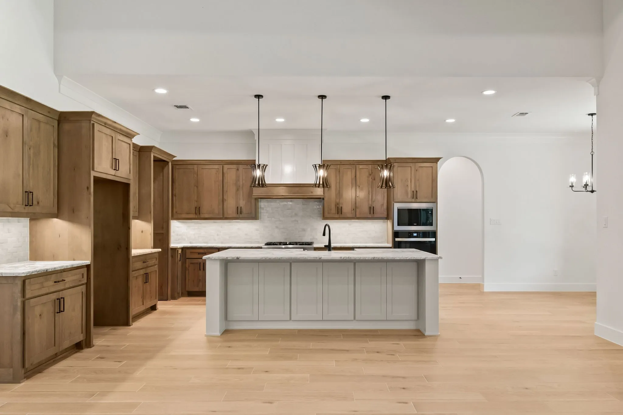Open-concept kitchen featuring light wood-finish flooring