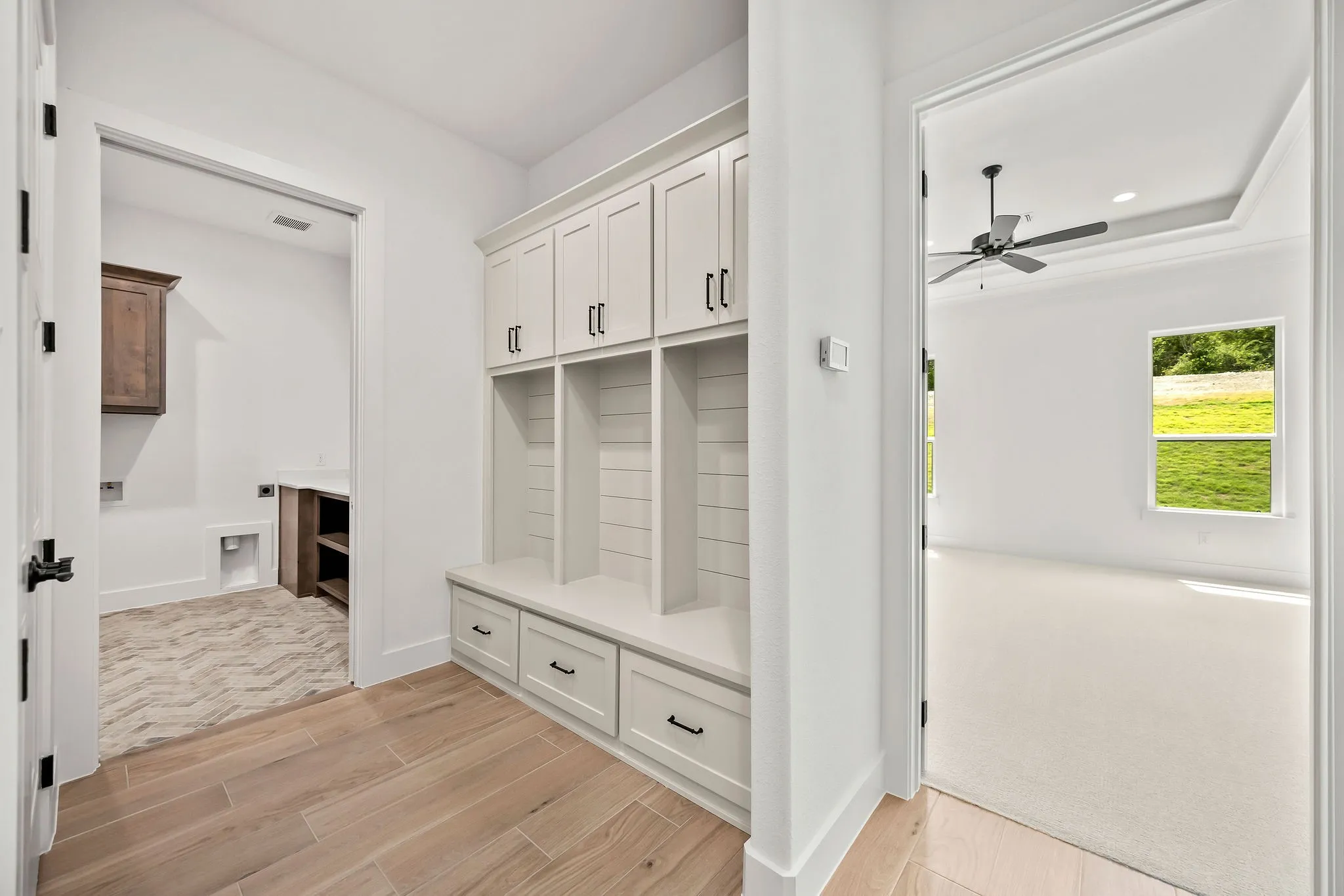 Built-in mudroom cabinetry with shaker-style doors, bench seating, and matte black hardware
